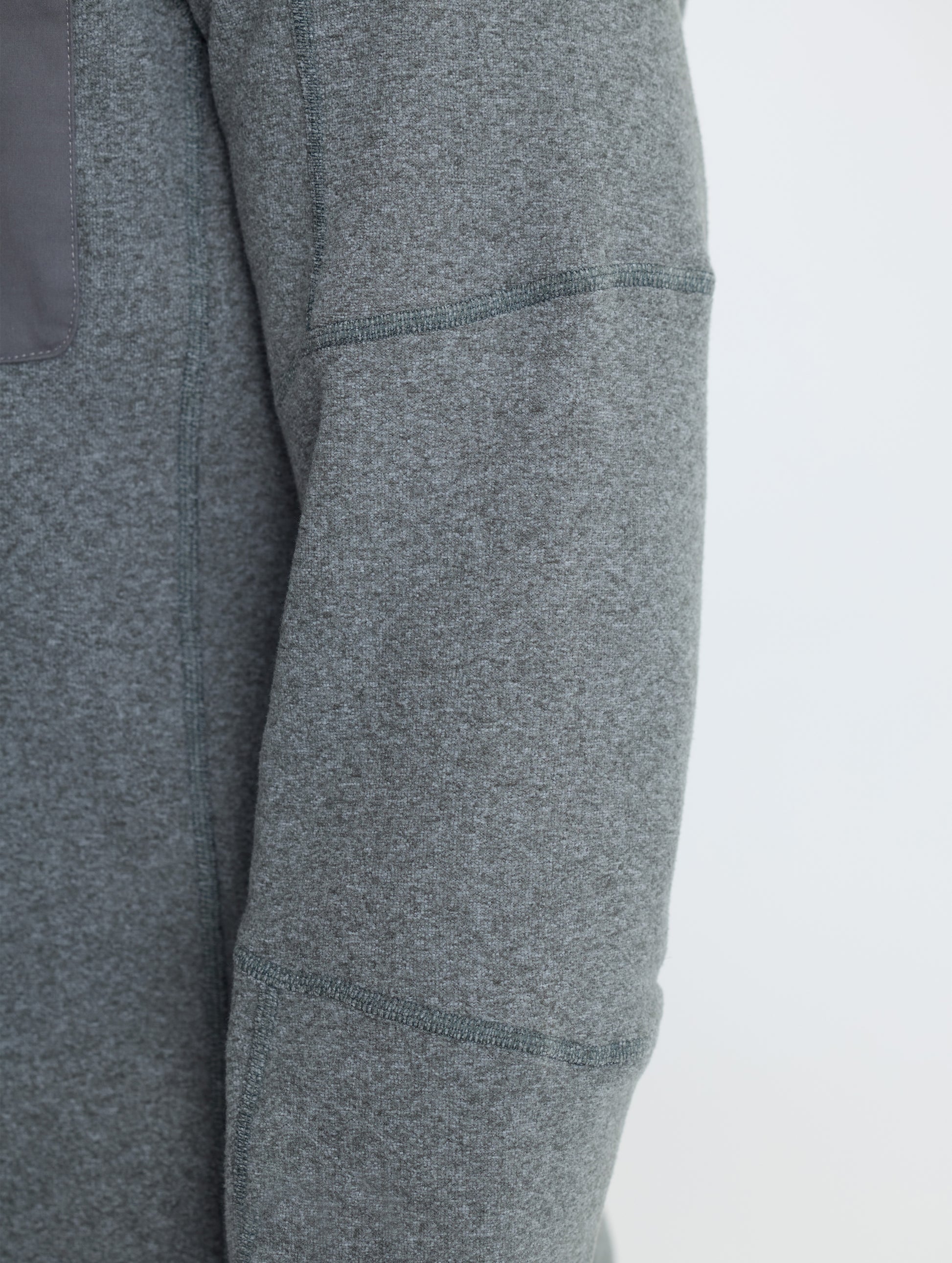 Closeup rear detail view of wearer's right sleeve of Sutherlin Half-Zip in Charcoal Heather from AETHER Apparel.