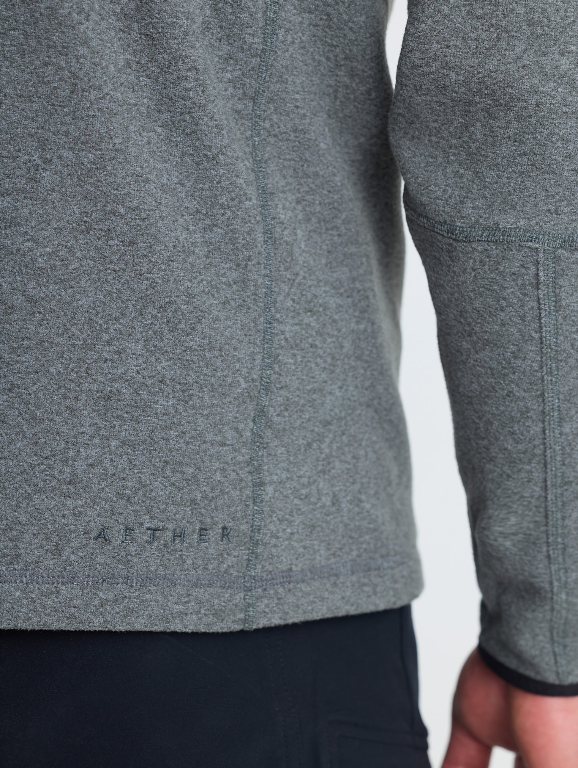 Closeup rear detail view of wearer's right sleeve of Sutherlin Half-Zip in Charcoal Heather from AETHER Apparel.