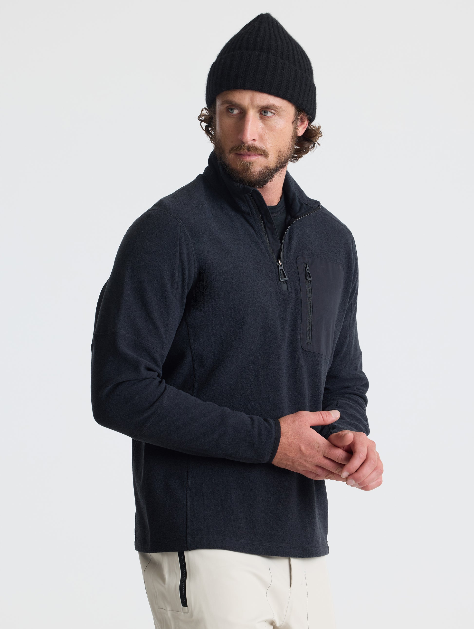 Angled view of man wearing Sutherlin Half-Zip in Onyx Black from AETHER Apparel.