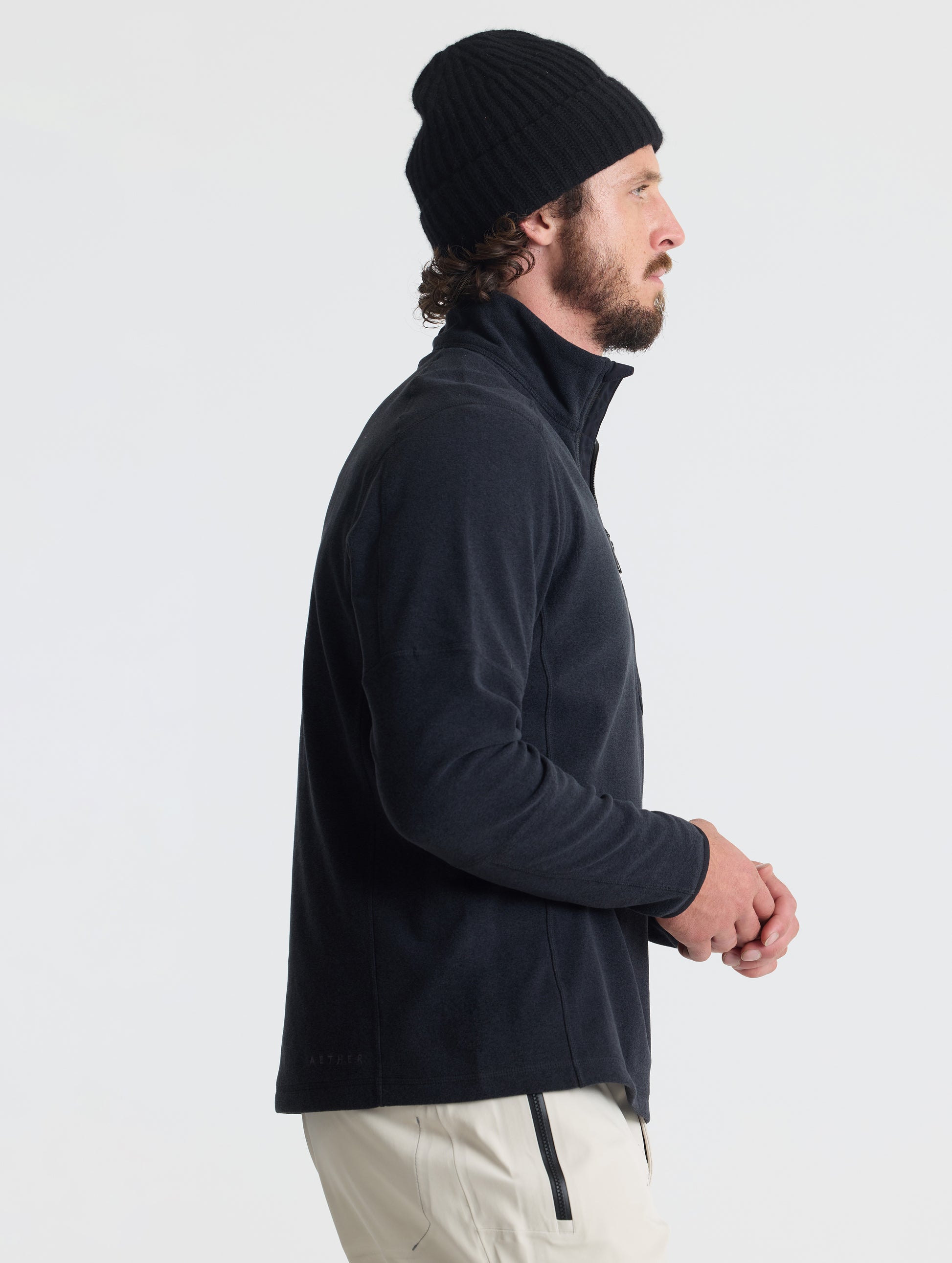 Right profile of man wearing Sutherlin Half-Zip in Onyx Black from AETHER Apparel.