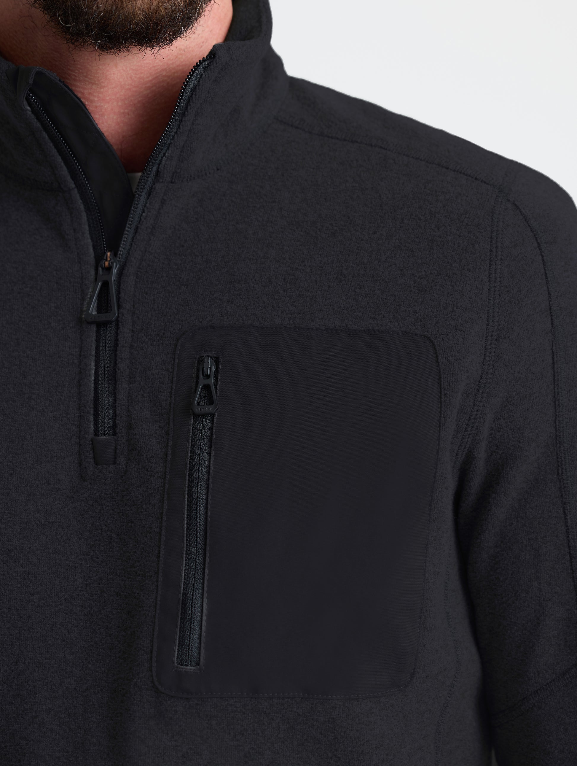 Closeup view of left shoulder detail of Sutherlin Half-Zip in Onyx Black from AETHER Apparel.