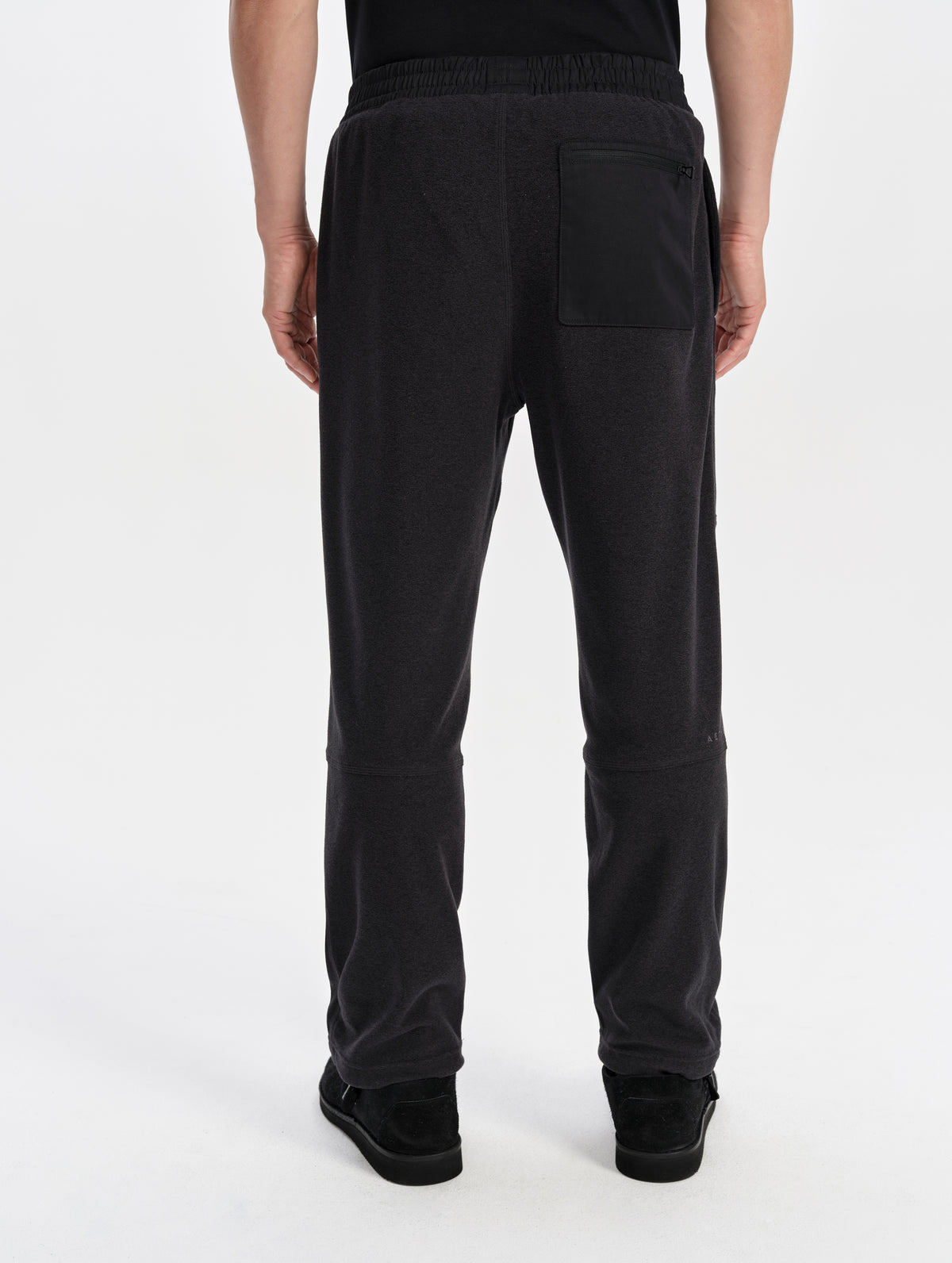 Rear lower-body view of man wearing the Sutherlin Pant in Onyx Black from AETHER Apparel.