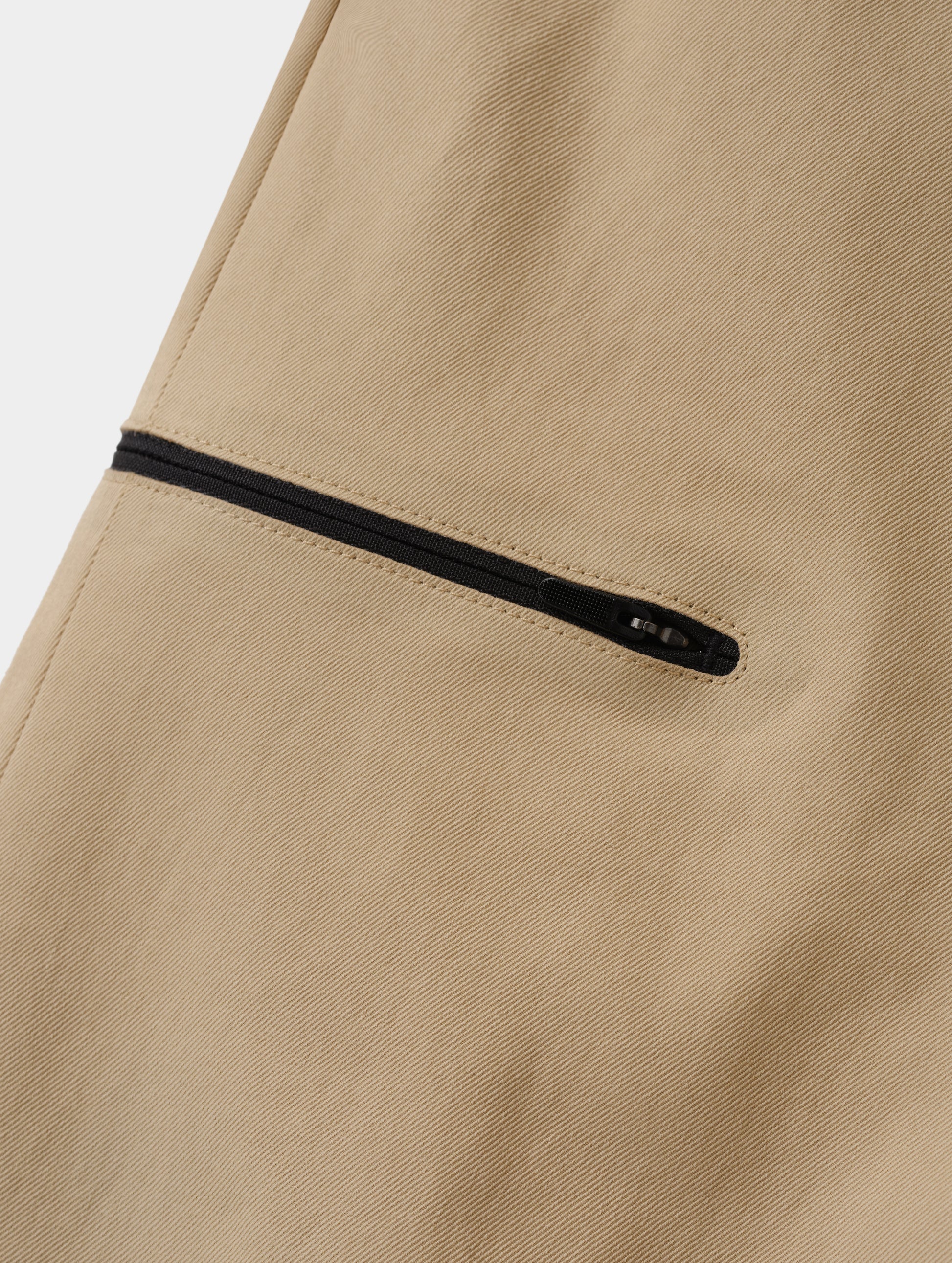 Closeup detailed view of the bonded zipper thigh pocket on the Walden Tech Pant in Desert Tan from AETHER Apparel. 