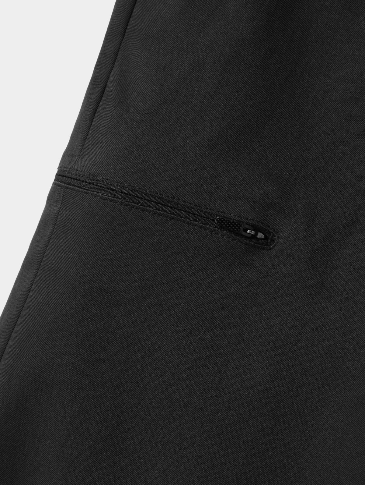 Closeup detailed view of the bonded zipper thigh pocket on the Walden Tech Pant in Onyx Black from AETHER Apparel. 