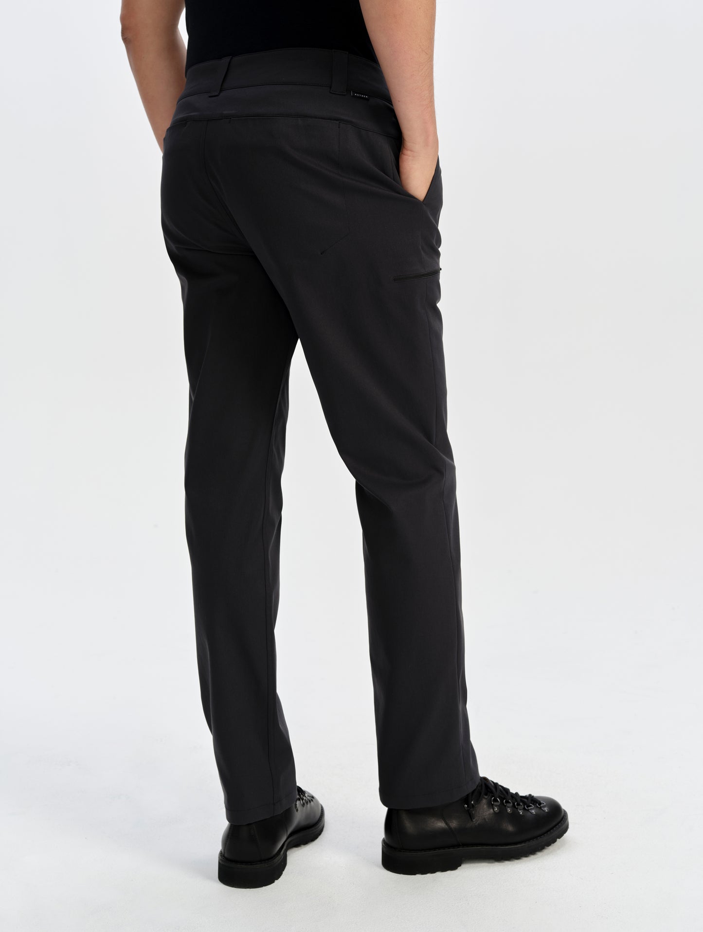 Rear lower-body view of man wearing the Walden Tech Pant in Onyx Black from AETHER Apparel. 