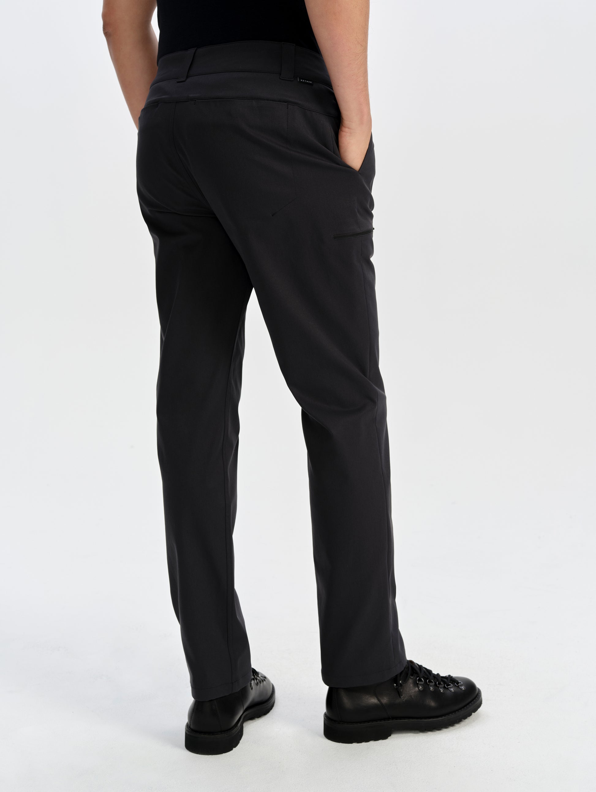 Rear lower-body view of man wearing the Walden Tech Pant in Onyx Black from AETHER Apparel. 