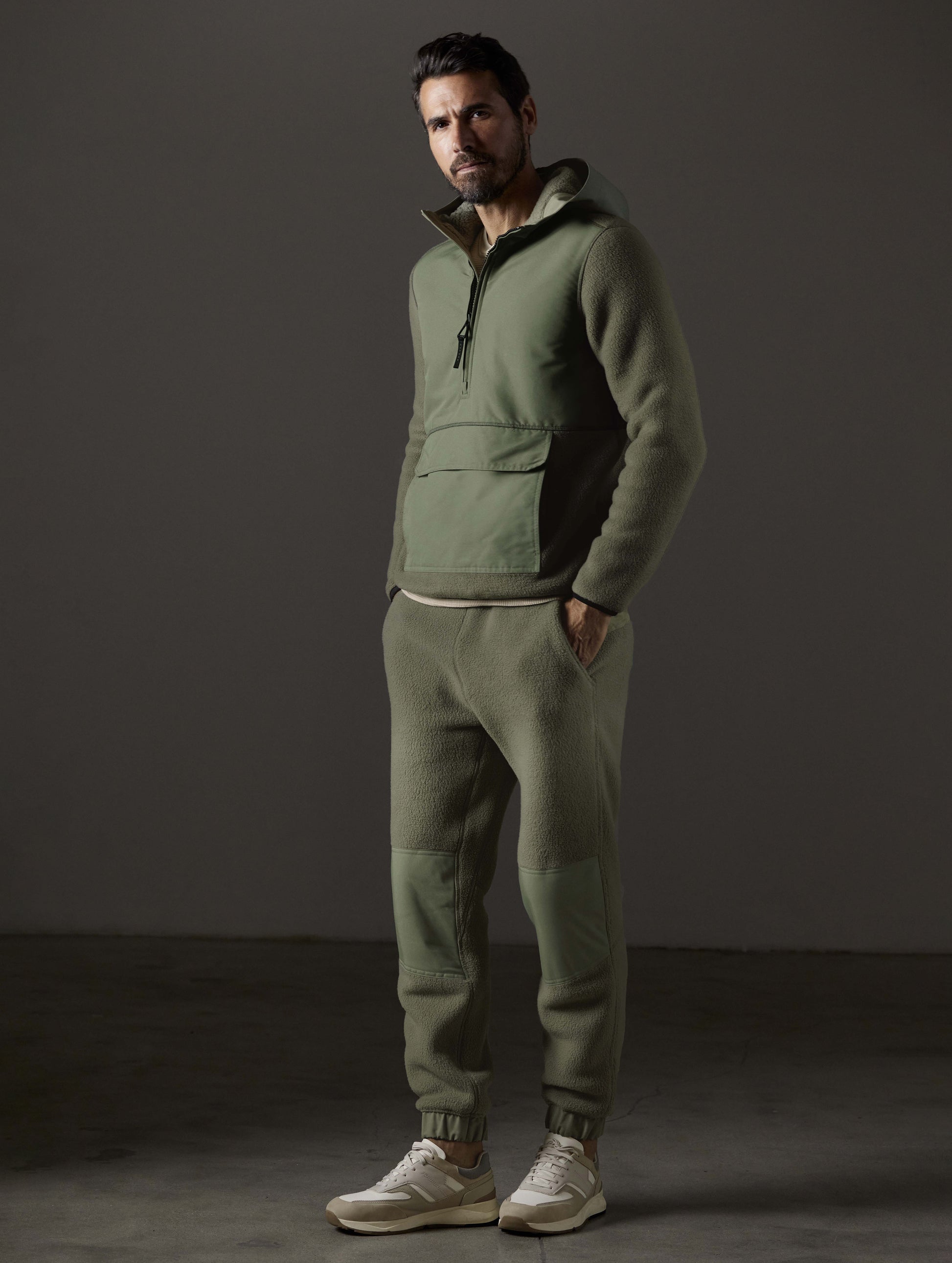 Front 3/4 full-body view of man wearing Walsh Hooded Anorak and Walsh Pant in Fern Green from AETHER Apparel.