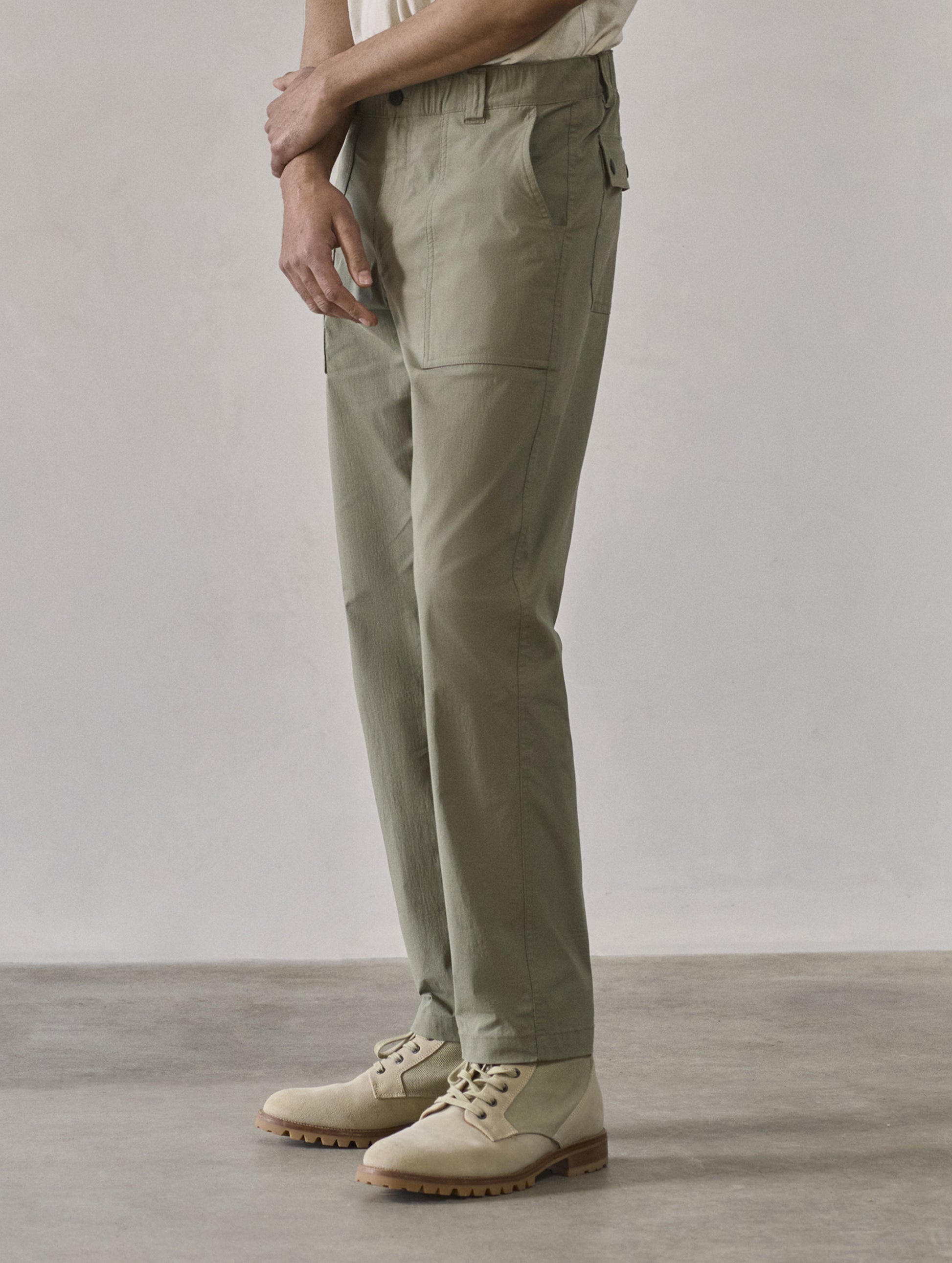 Front 3/4 lower body view of man wearing Zermatt Hiking Pant in Fern Green from AETHER Apparel.