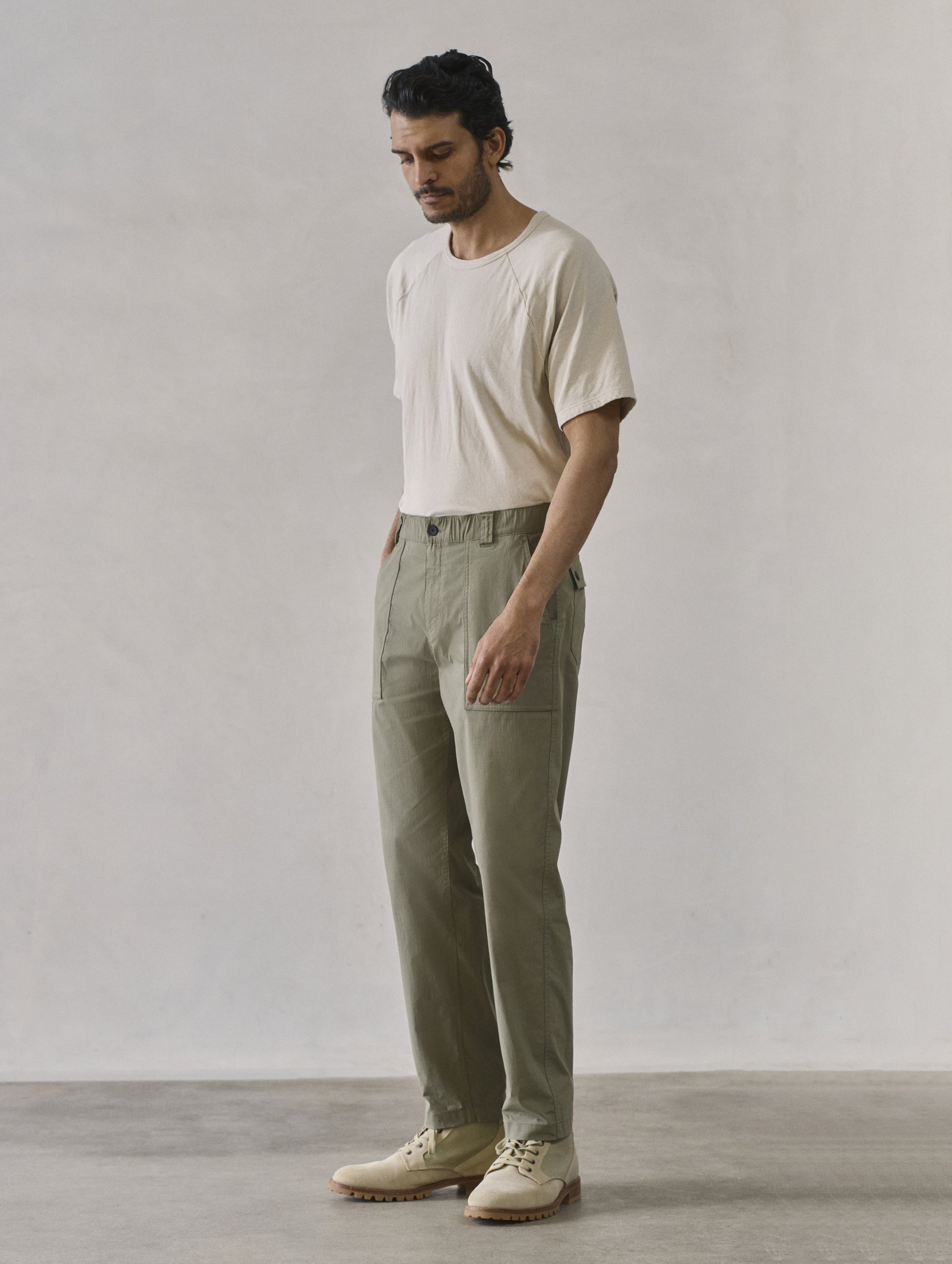 Front 3/4 full body view of man wearing Zermatt Hiking Pant in Fern Green from AETHER Apparel.