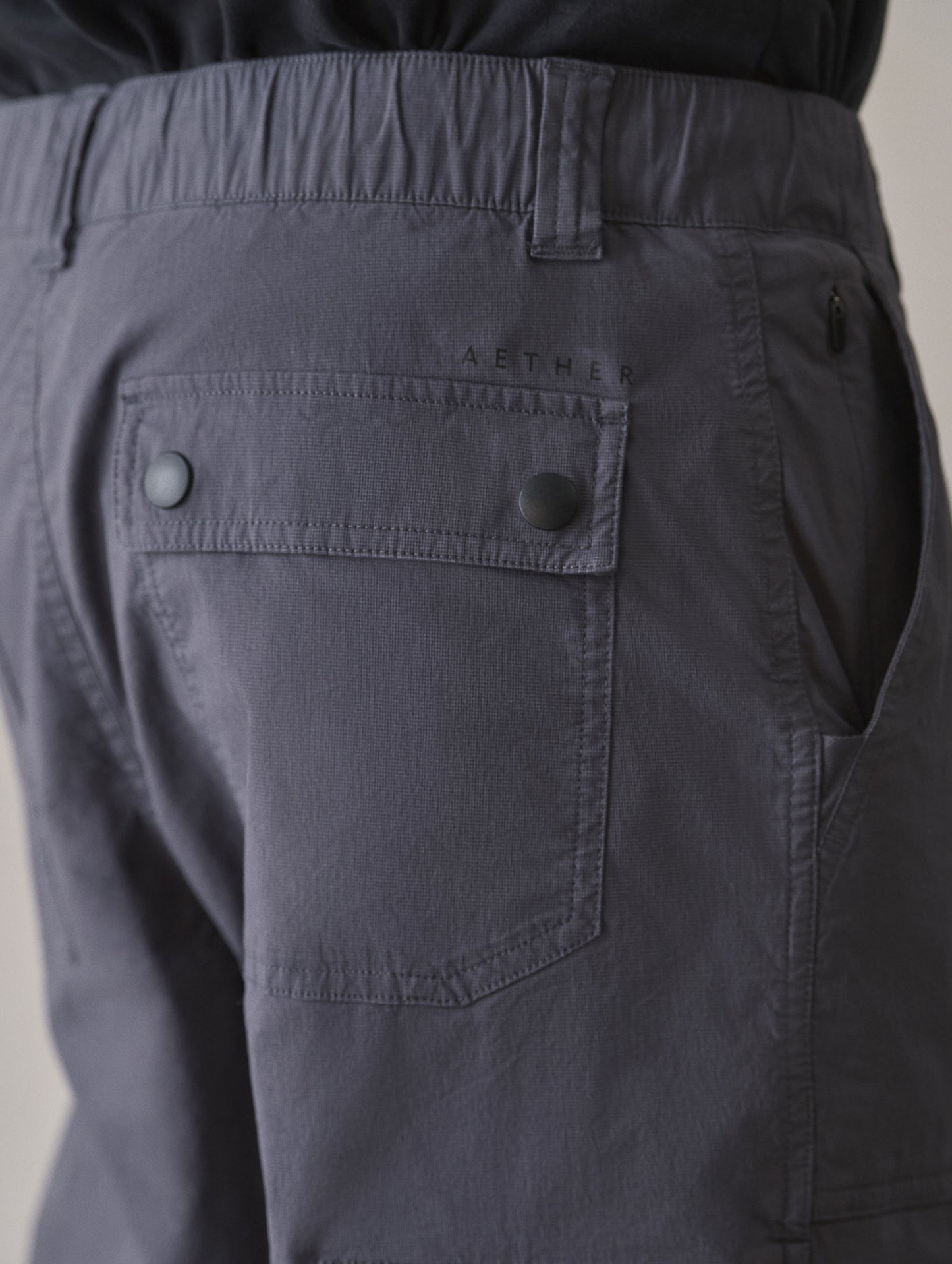 Closeup detailed view of the back patch pockets with flap-snap closures on the Zermatt Hiking Pant in Graphite from AETHER Apparel.