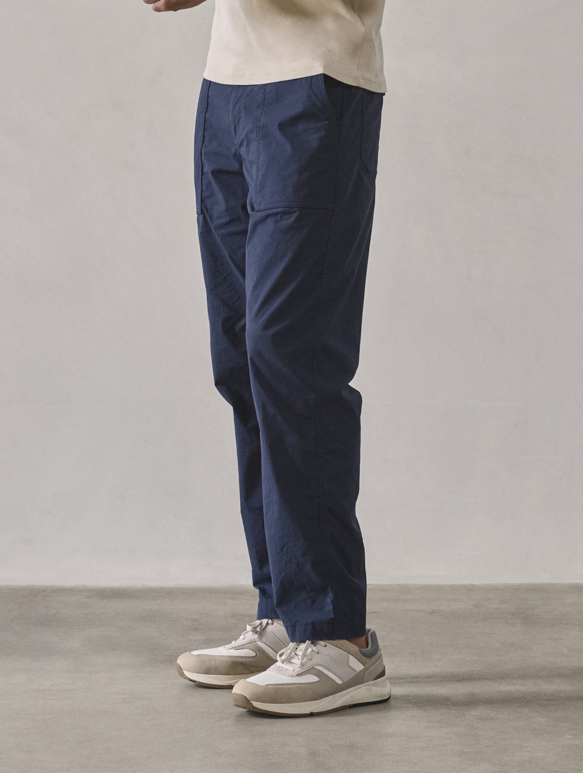 Front 3/4 lower body view of man wearing Zermatt Hiking Pant in Total Eclipse dark blue from AETHER Apparel.