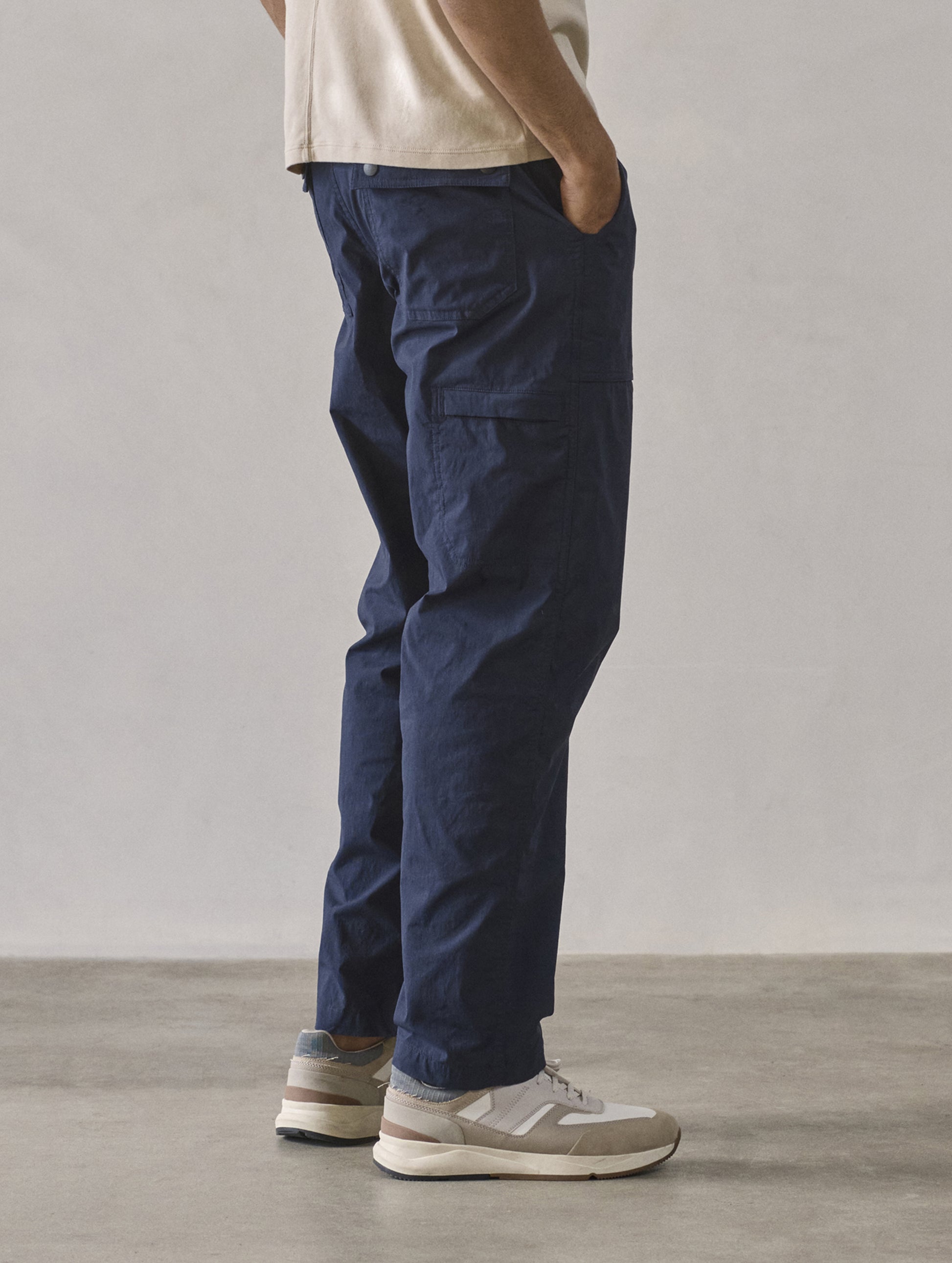 Rear 3/4 lower body view of man wearing Zermatt Hiking Pant in Total Eclipse dark blue from AETHER Apparel.