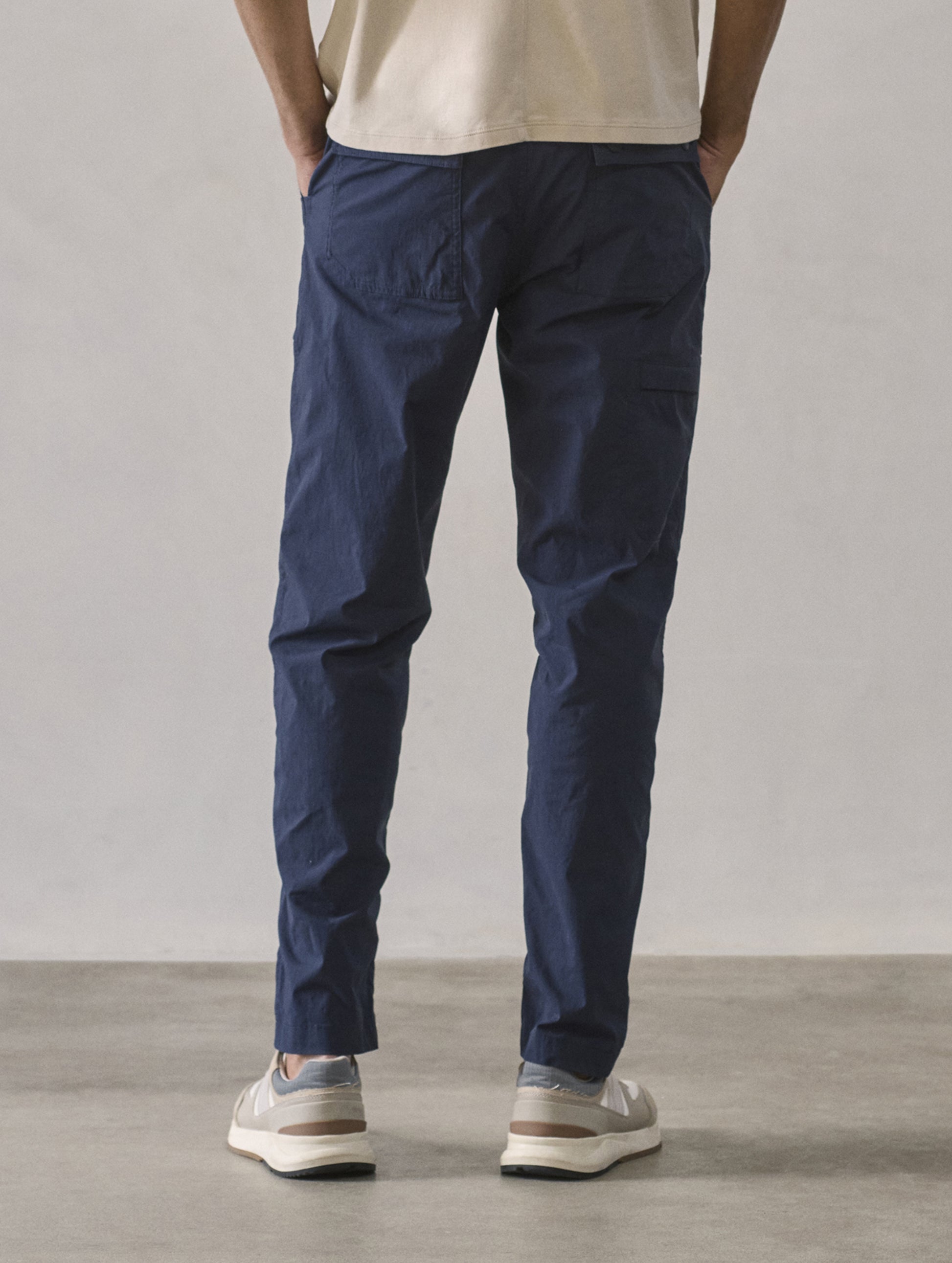 Rear lower body view of man wearing Zermatt Hiking Pant in Total Eclipse dark blue from AETHER Apparel.