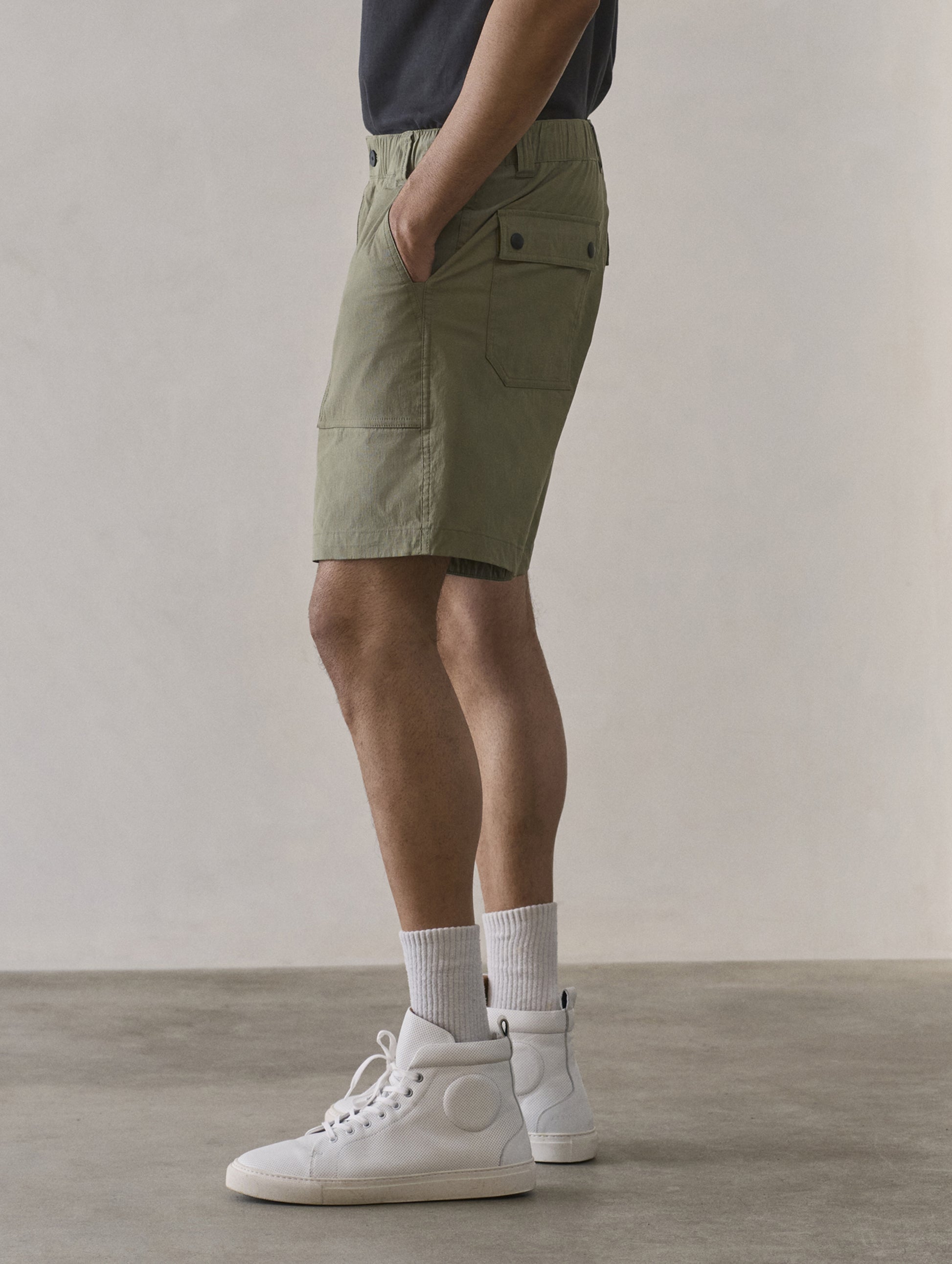 Side profile lower body view of man wearing Zermatt Hiking Short in Fern Green from AETHER Apparel.