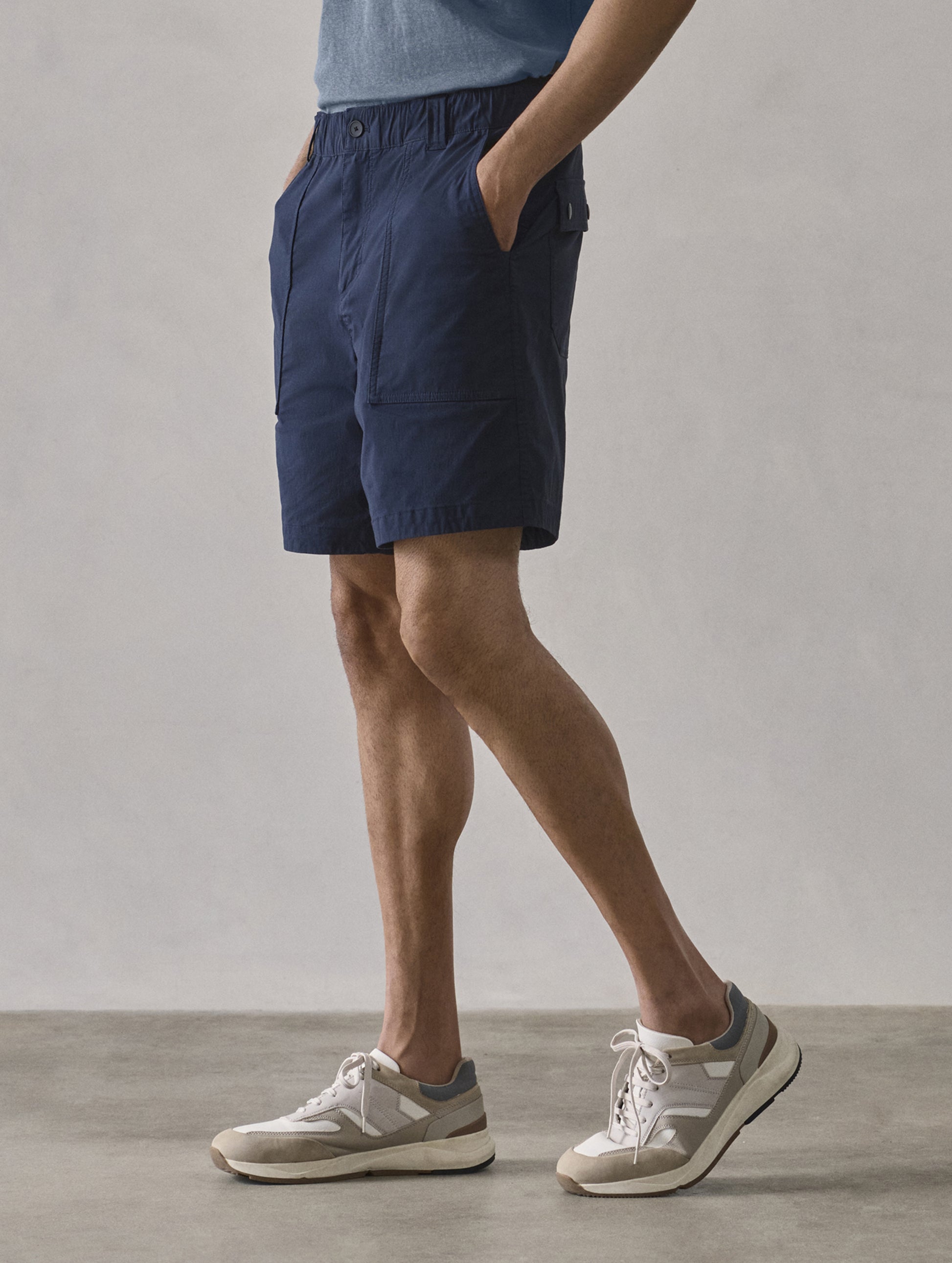 Front 3/4 lower body view of man wearing Zermatt Hiking Short in Total Eclipse dark blue from AETHER Apparel.