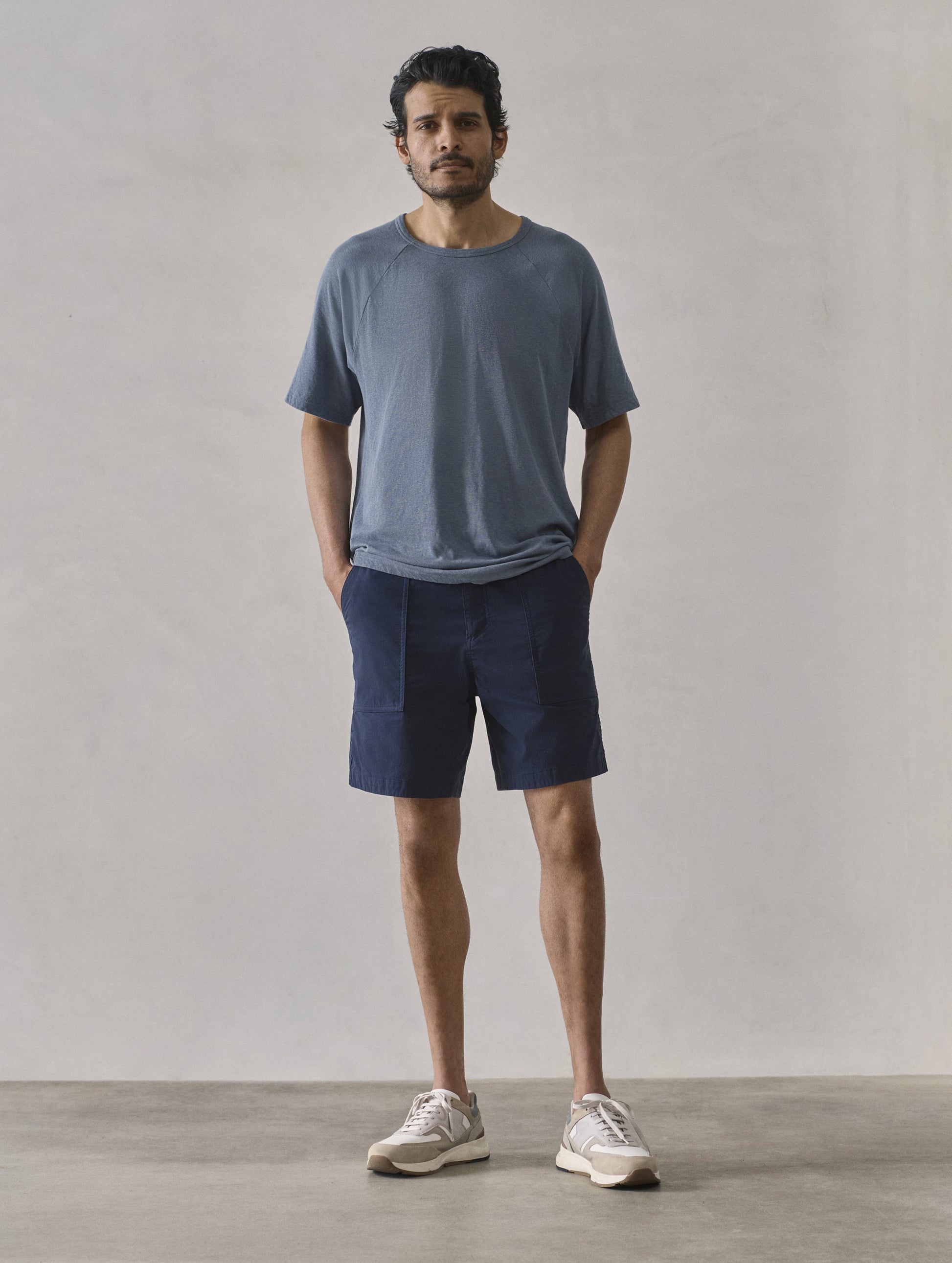 Front full-body view of man wearing Zermatt Hiking Short in Total Eclipse dark blue from AETHER Apparel.