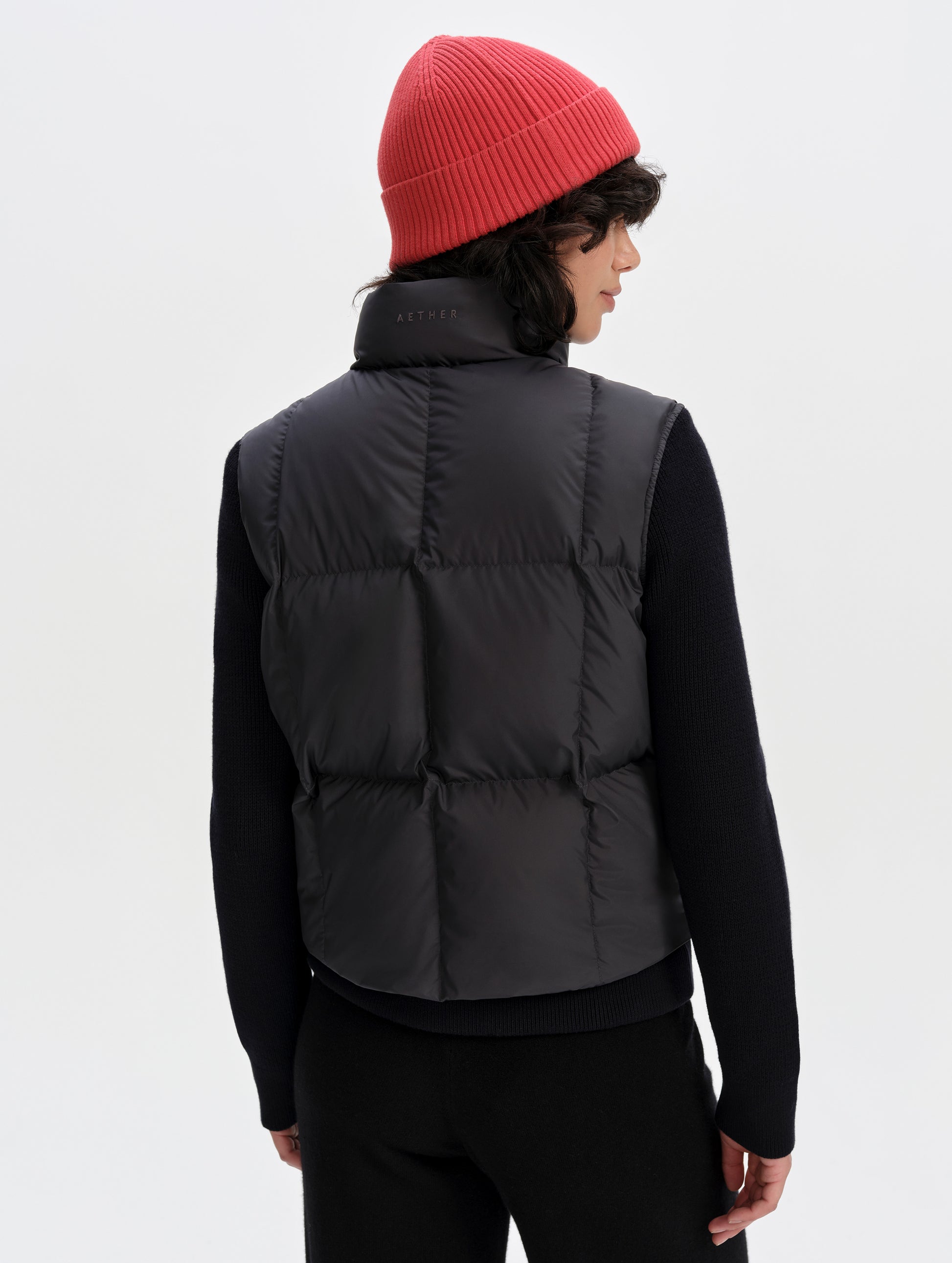 Rear upper-body view of woman wearing the Nina Sweater Jacket 2.0 in Onyx Black from AETHER Apparel.