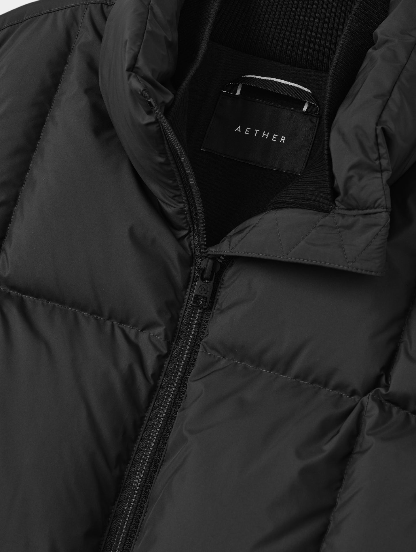 Closeup detailed view of the center-front zipper and inner and outer collars on the Nina Sweater Jacket 2.0 in Onyx Black from AETHER Apparel.
