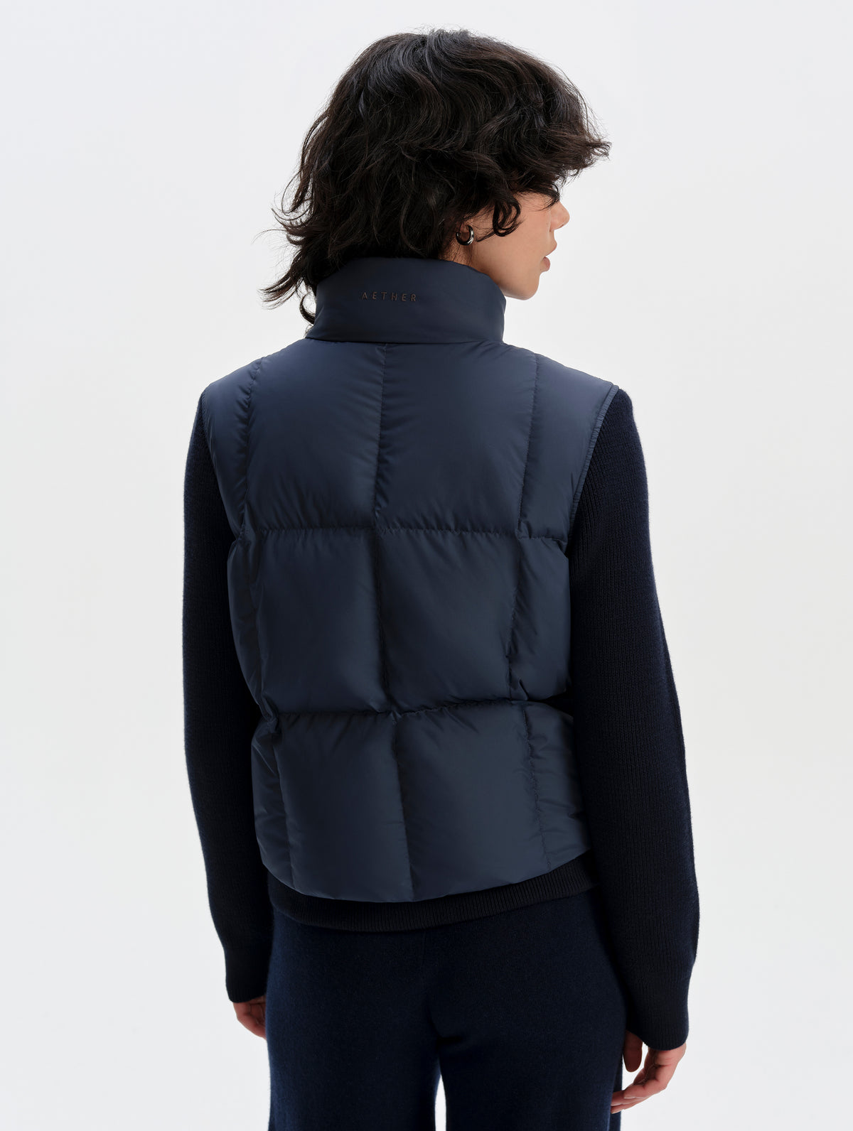 Rear upper-body view of woman wearing the Nina Sweater Jacket 2.0 in Total Eclipse from AETHER Apparel.