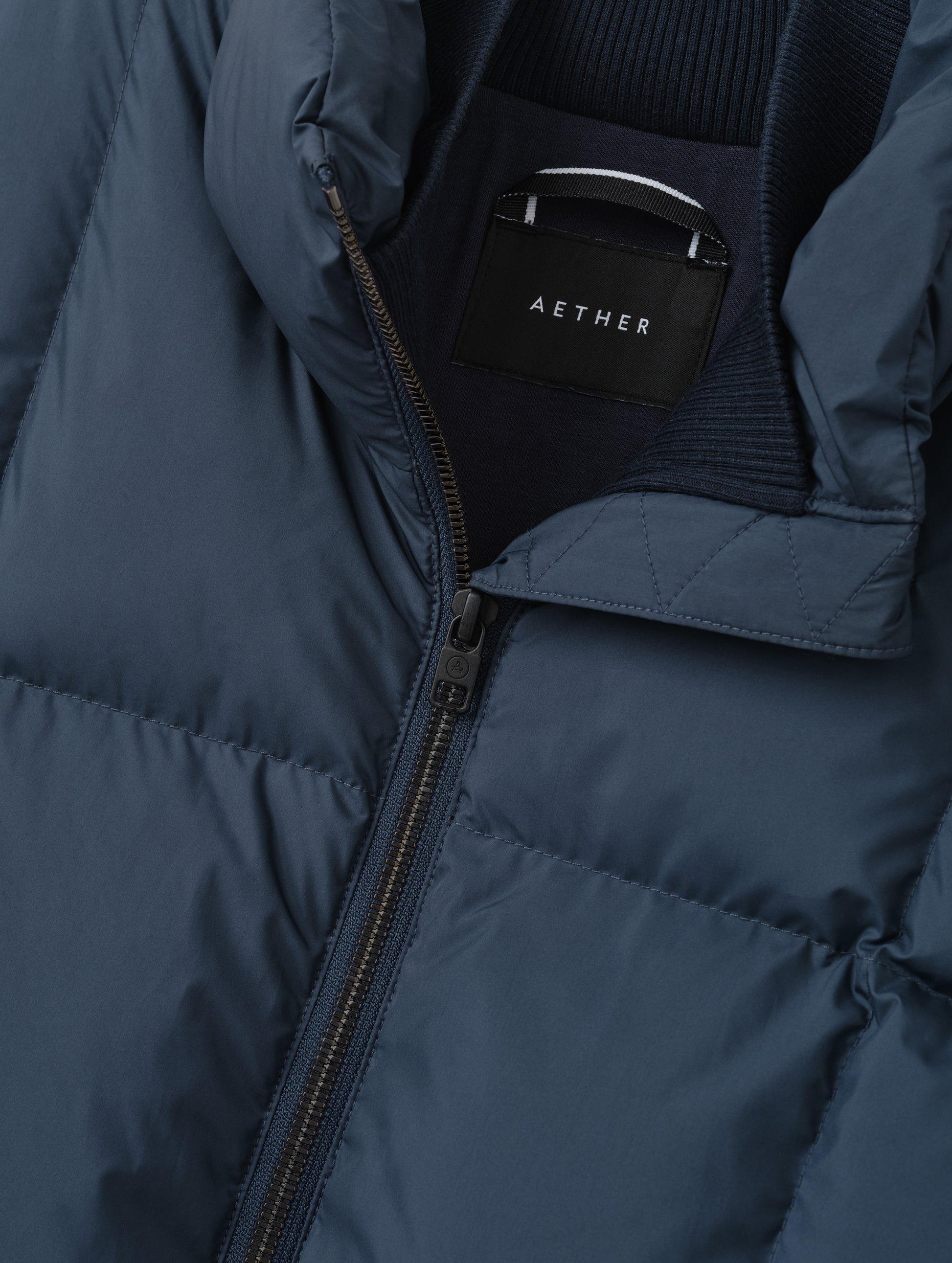 Closeup detailed view of the center-front zipper and inner and outer collars on the Nina Sweater Jacket 2.0 in Total Eclipse from AETHER Apparel.