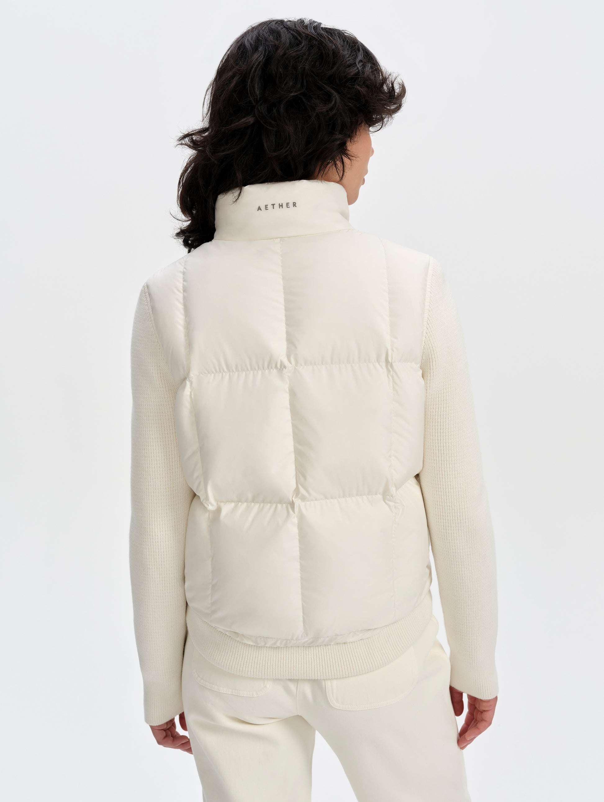 Rear upper-body view of woman wearing the Nina Sweater Jacket 2.0 in Winter White from AETHER Apparel.