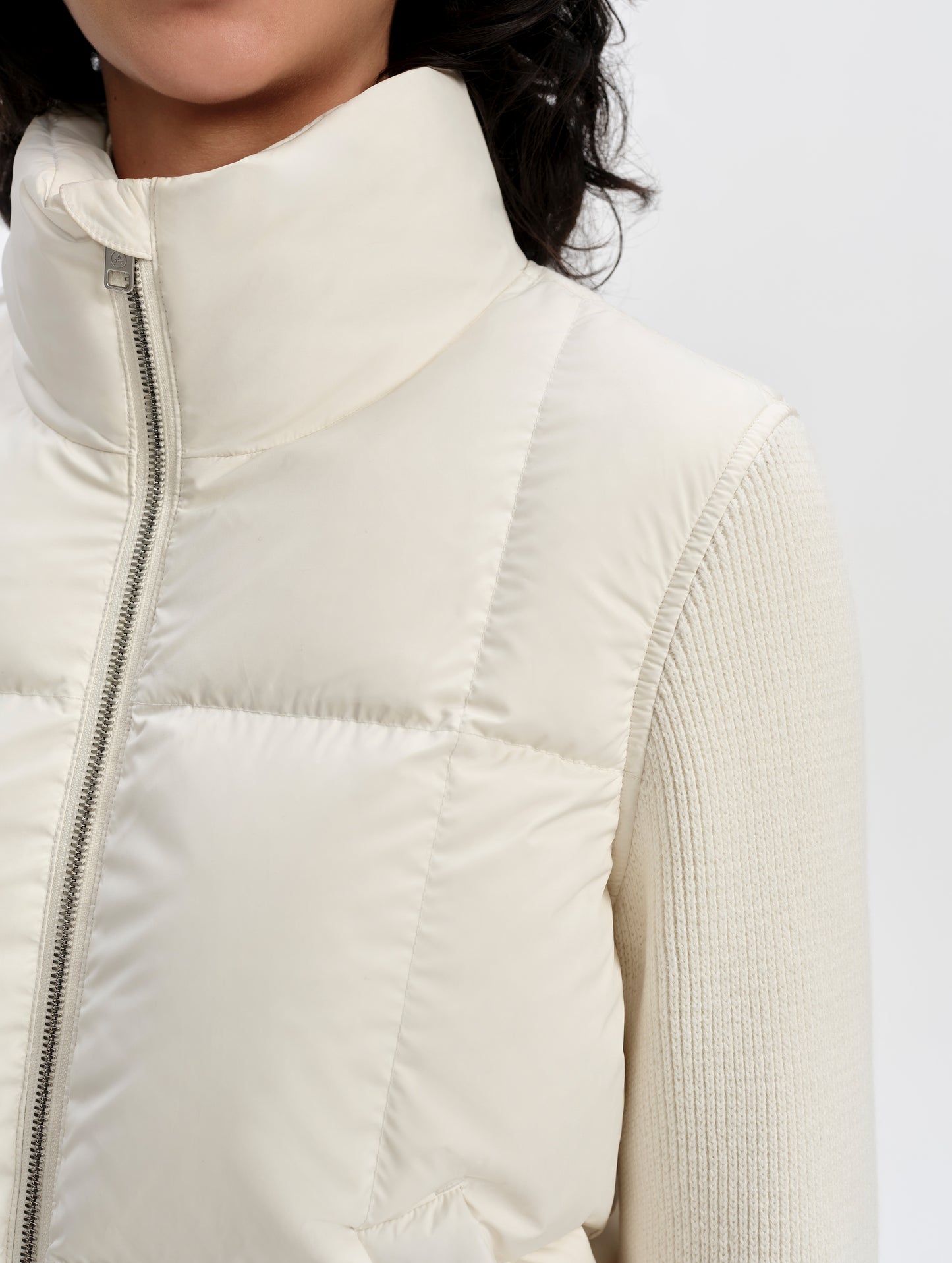 Closeup detailed view of the main insulated body construction and cotton-cashmere sleeves on the Nina Sweater Jacket 2.0 in Winter White from AETHER Apparel.