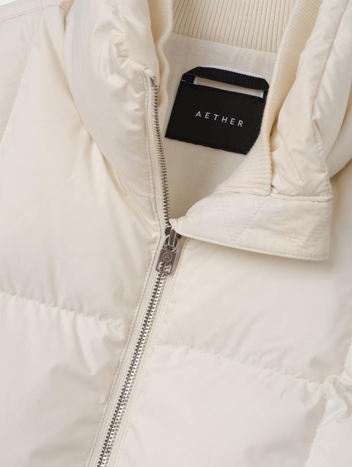 Closeup detailed view of the center-front zipper and inner and outer collars on the Nina Sweater Jacket 2.0 in Winter White from AETHER Apparel.