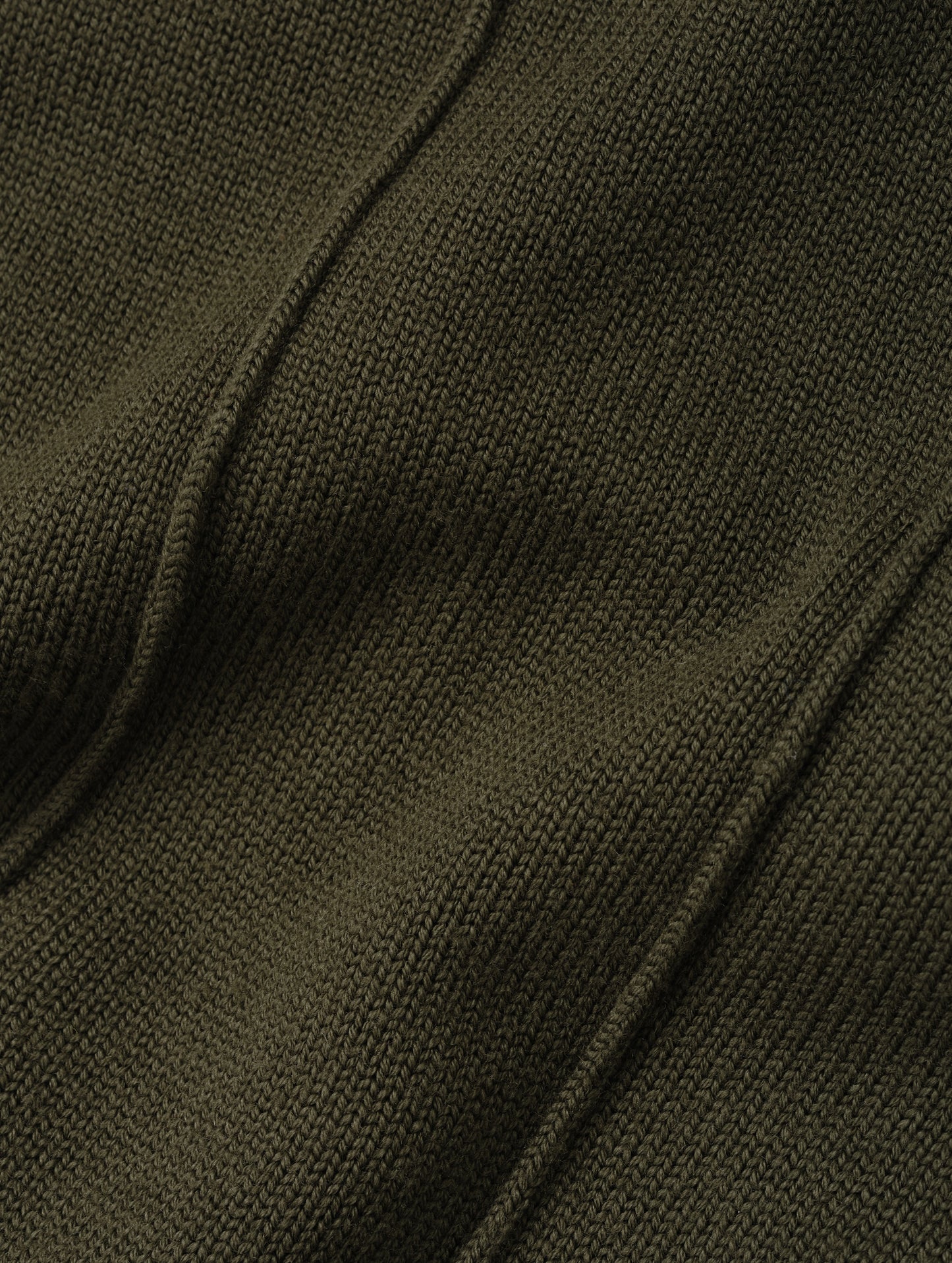 Closeup detailed view of the knitted merino wool construction on the Riley Full-Zip Sweater in Forest Green from AETHER Apparel. 