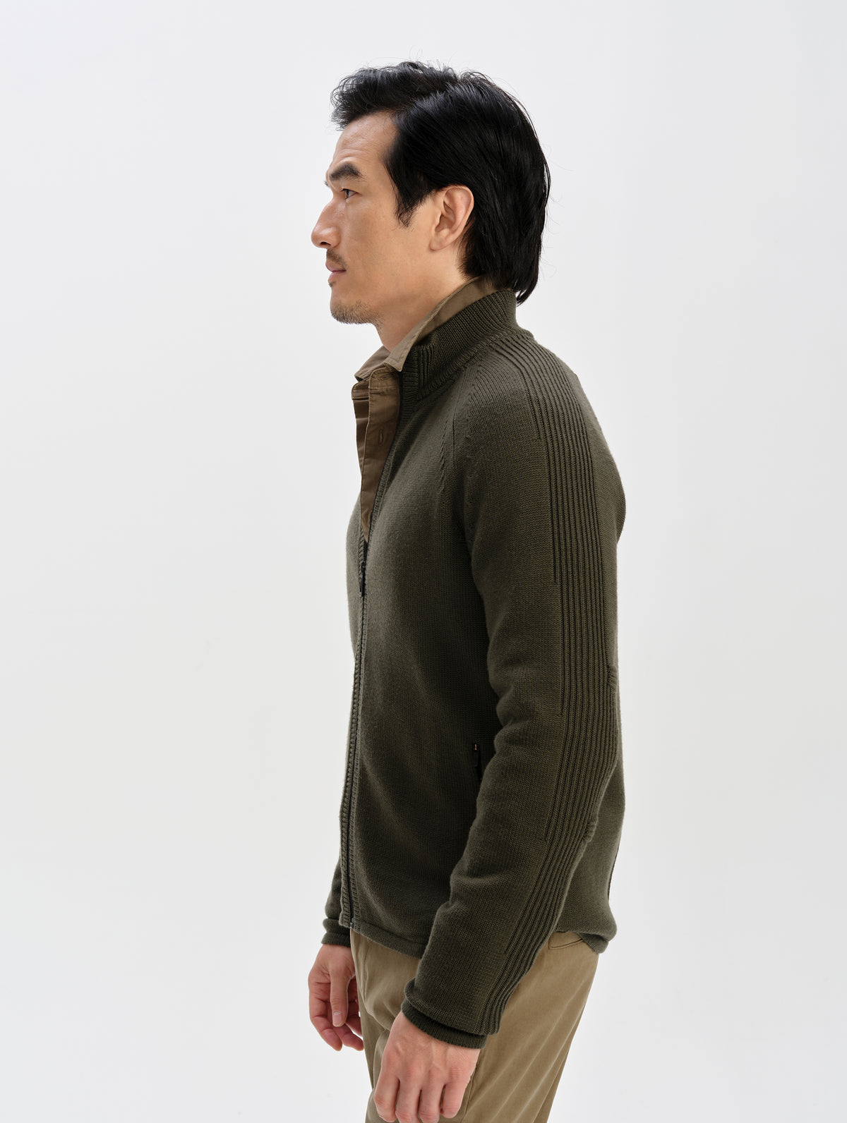 Side profile upper-body view of man wearing the Riley Full-Zip Sweater in Forest Green from AETHER Apparel. 