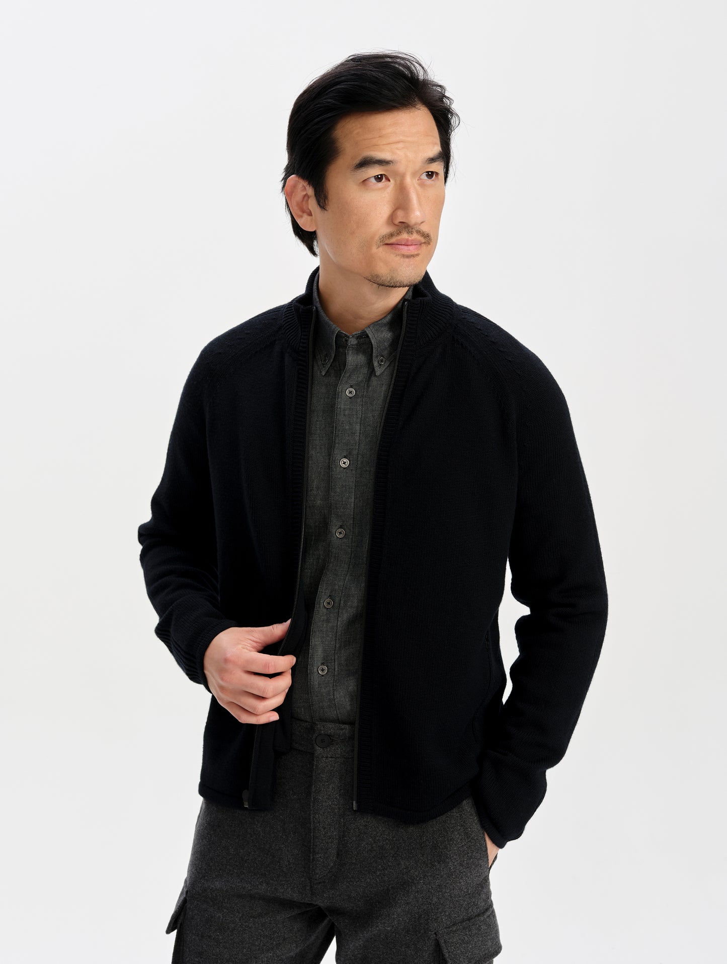 Front upper-body view of man wearing the Riley Full-Zip Sweater in Onyx Black from AETHER Apparel. 