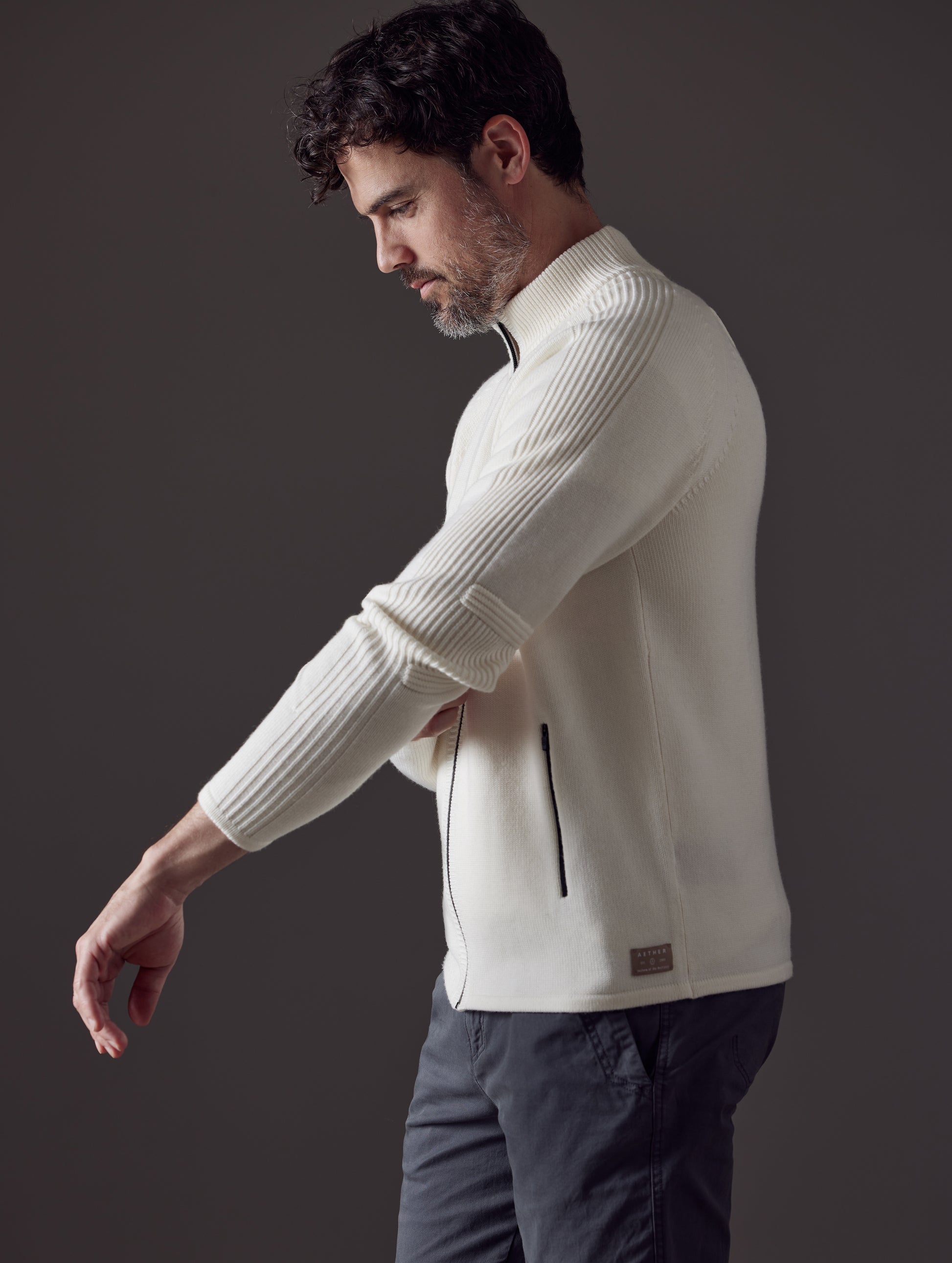 Man wearing white Riley Full-Zip Sweater from AETHER Apparel