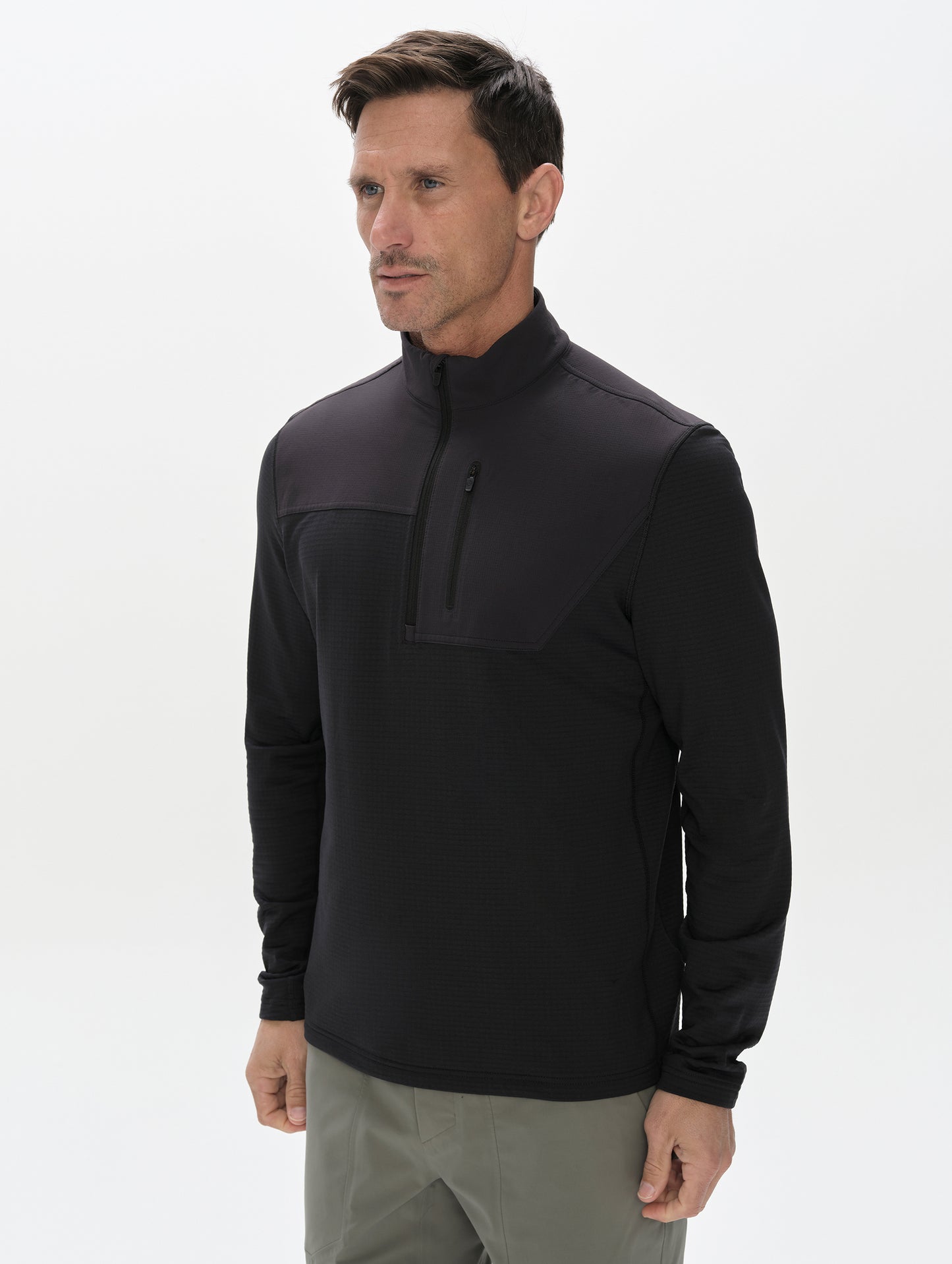 Front, 3/4 upper-body view of man wearing the Rocklin Half-Zip in Onyx Black from AETHER Apparel.