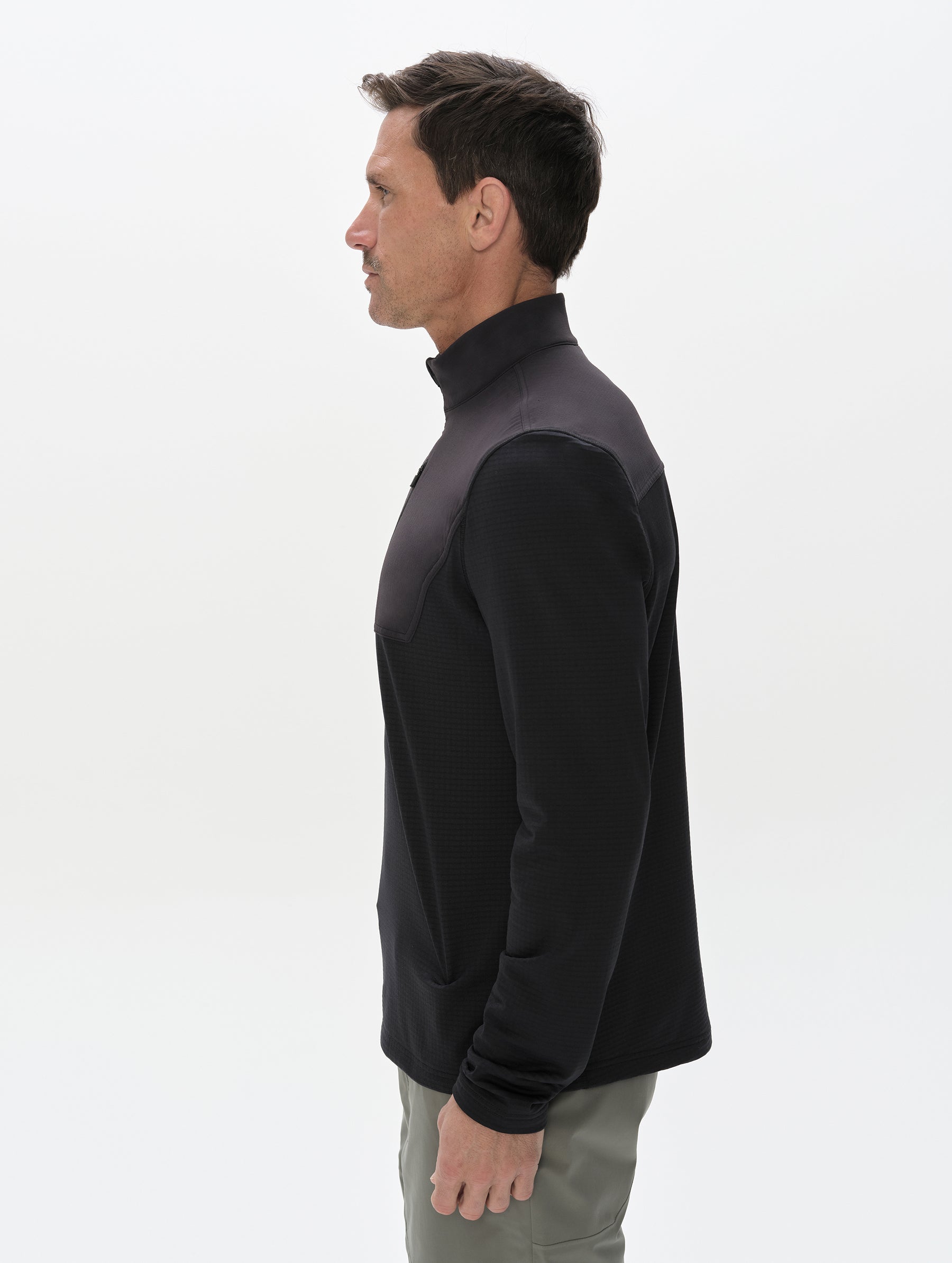 Side profile, upper-body view of man wearing the Rocklin Half-Zip in Onyx Black from AETHER Apparel.