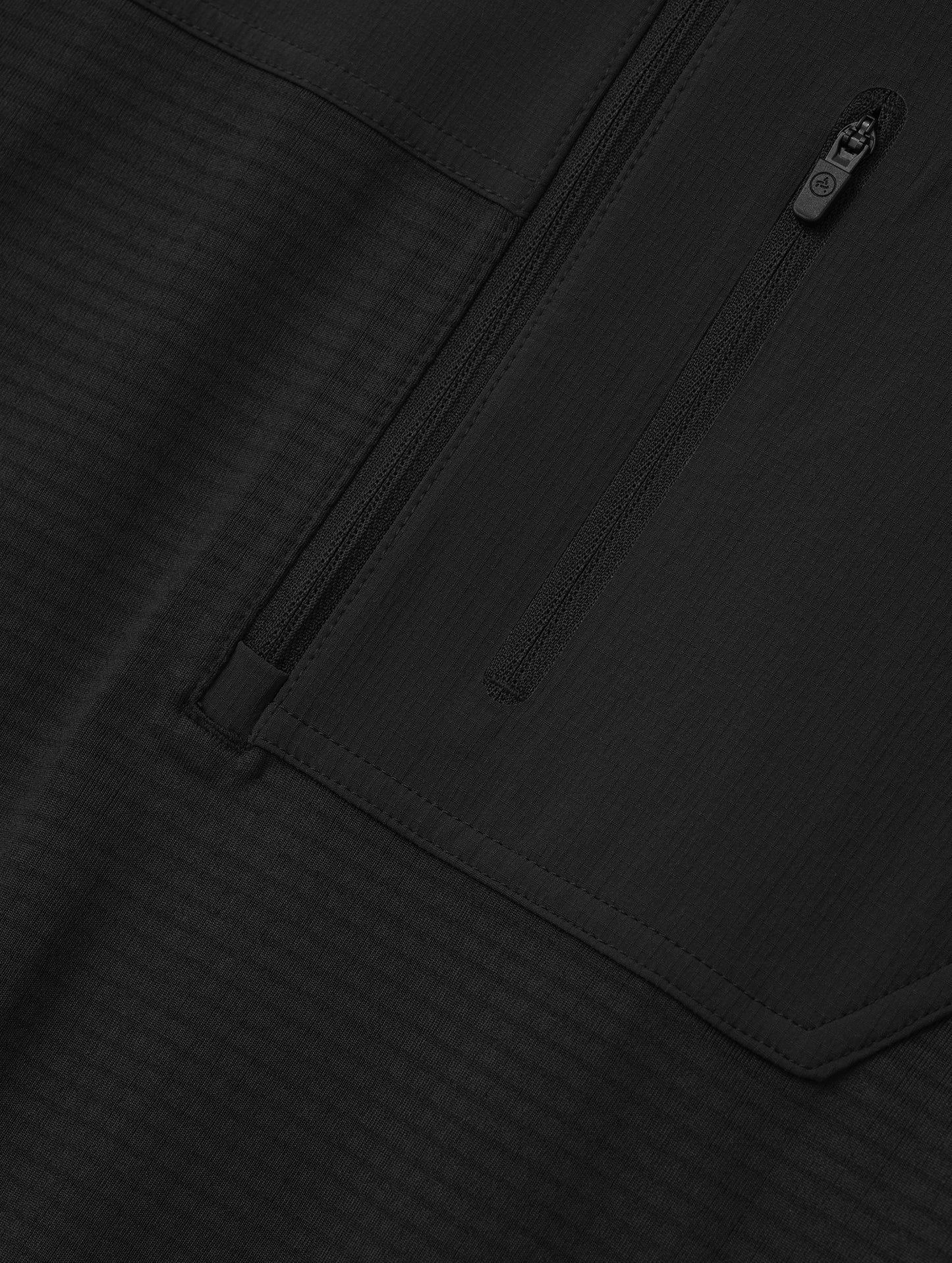 Closeup detailed view of the offset, zipper-secured chest pocket on the Rocklin Half-Zip in Onyx Black from AETHER Apparel.