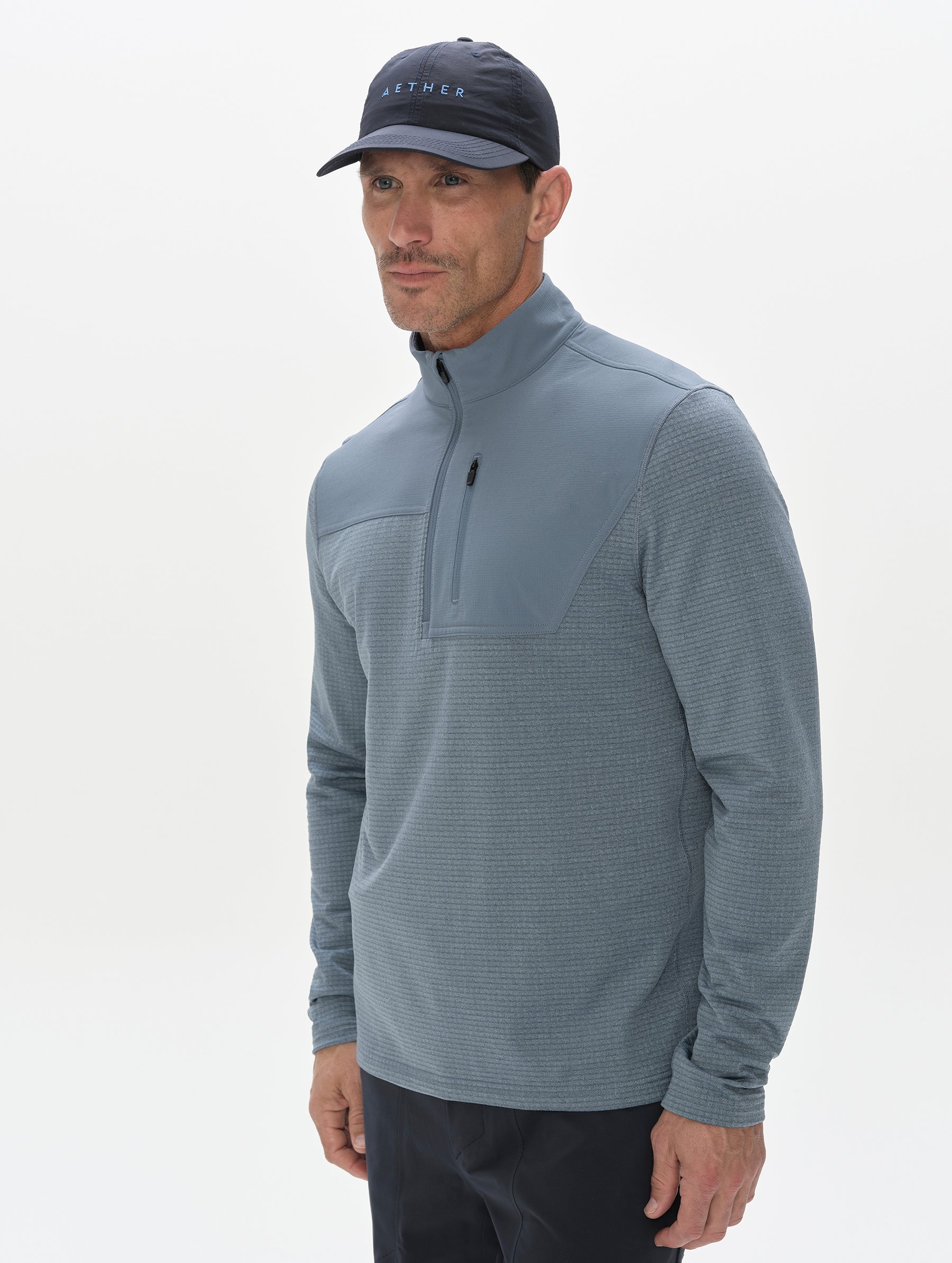Front, 3/4 upper-body view of man wearing the Rocklin Half-Zip in Portal Blue from AETHER Apparel.