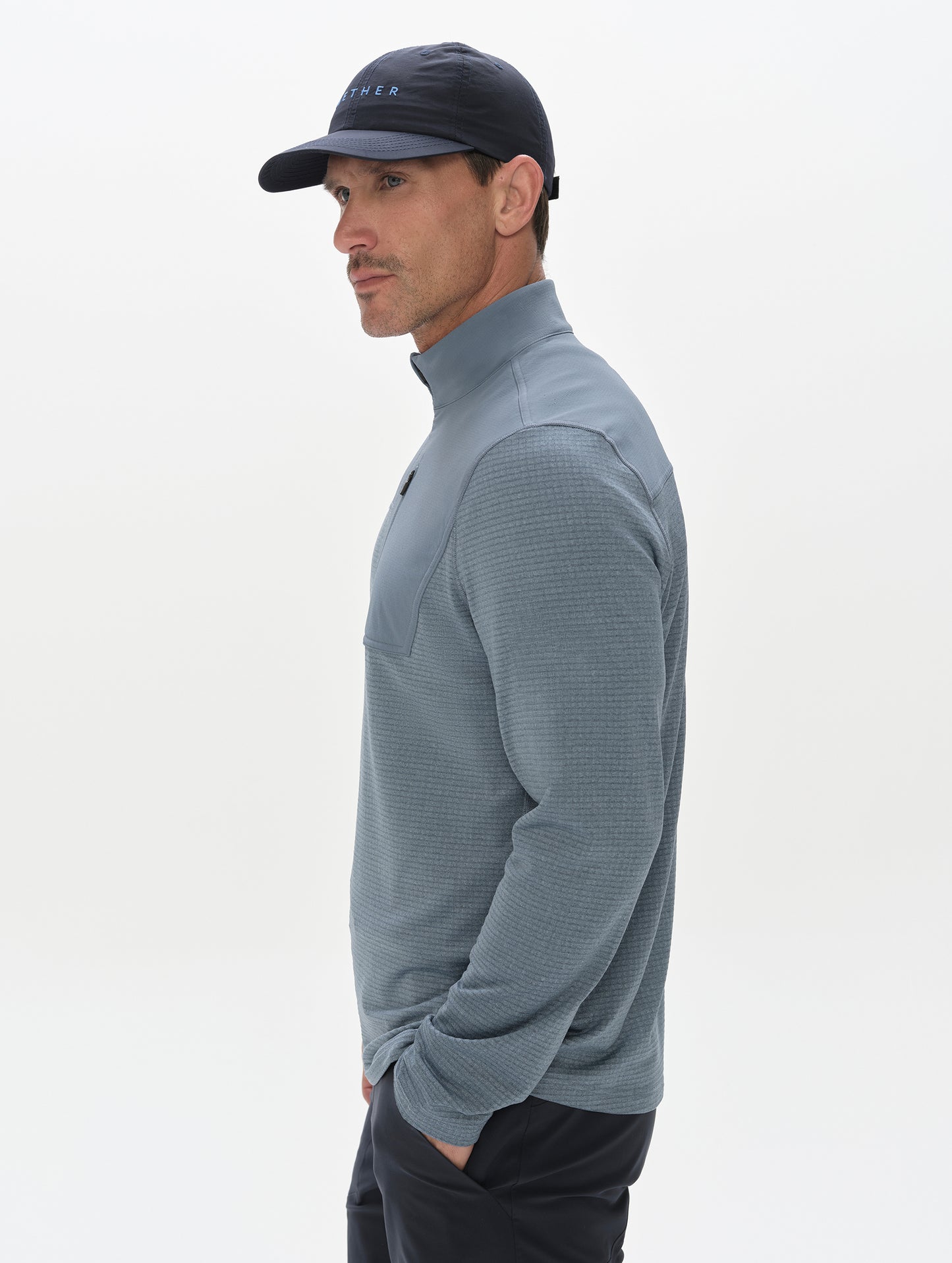 Side profile view of man wearing the Rocklin Half-Zip in Portal Blue from AETHER Apparel.