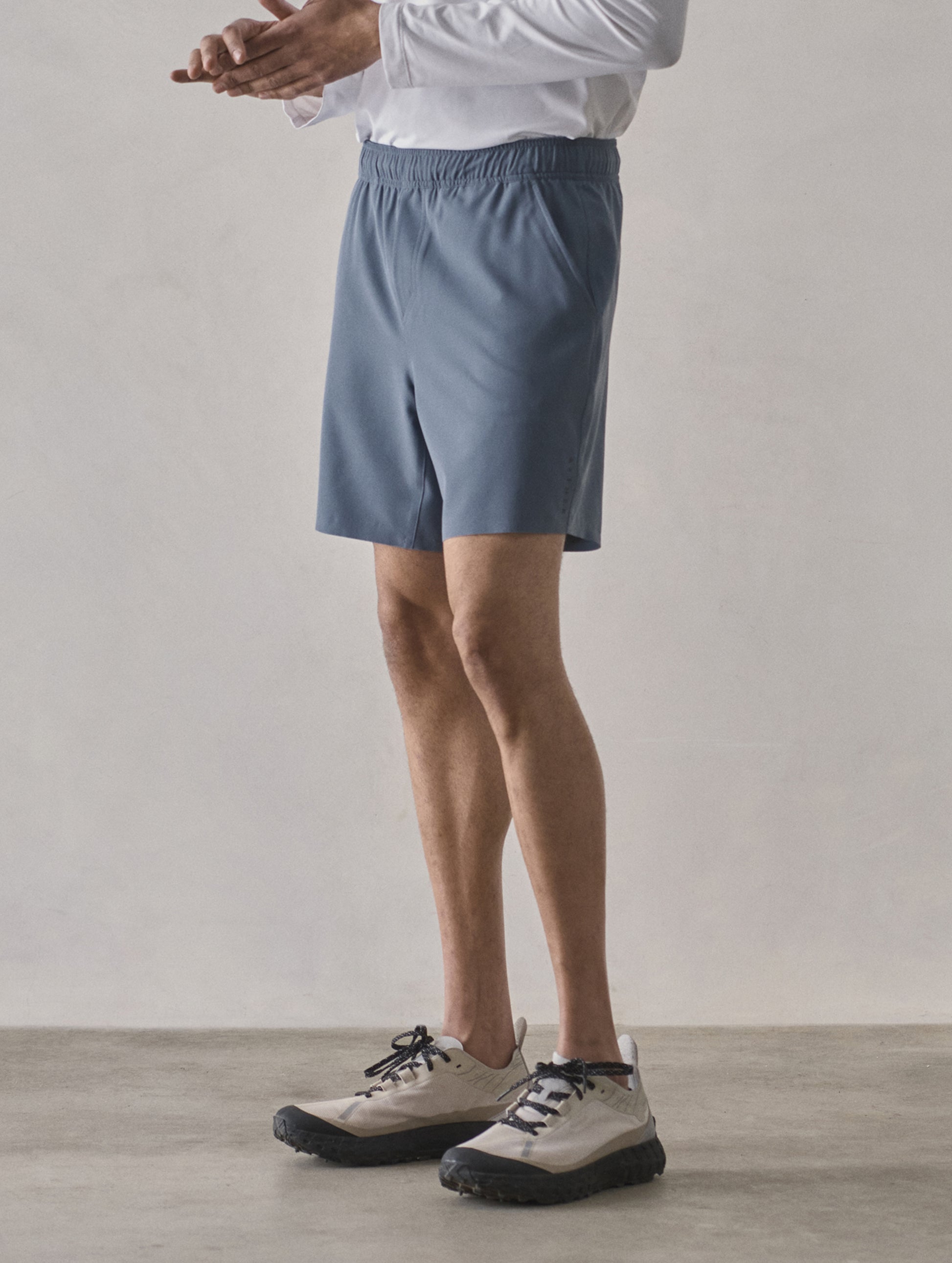 Front 3/4 lower-body view of man wearing Rogue Hybrid Short in Portal Blue from AETHER Apparel.