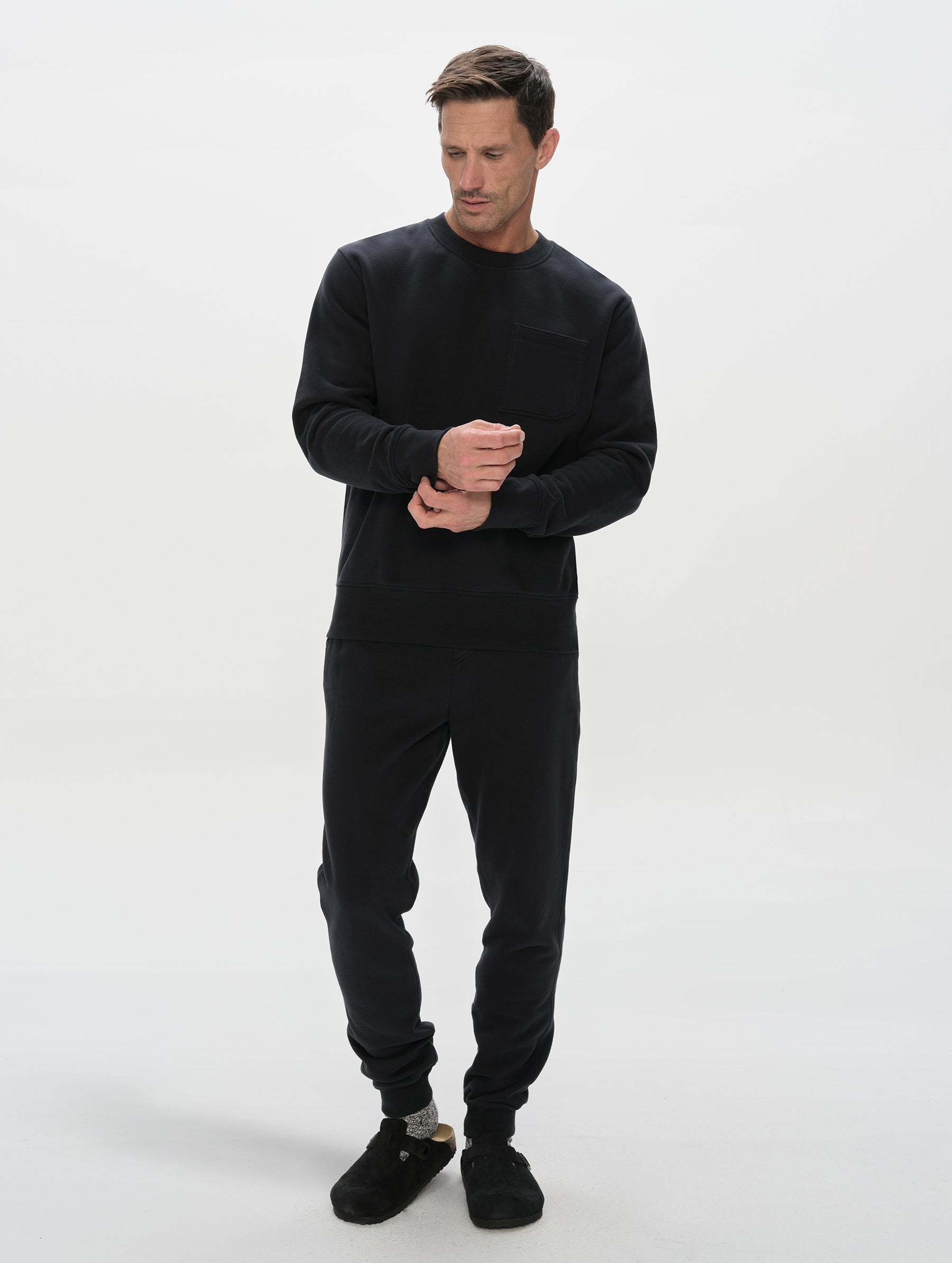 Front, full-body view of man wearing the Rylan Crewneck Sweatshirt in Onyx Black from AETHER Apparel.