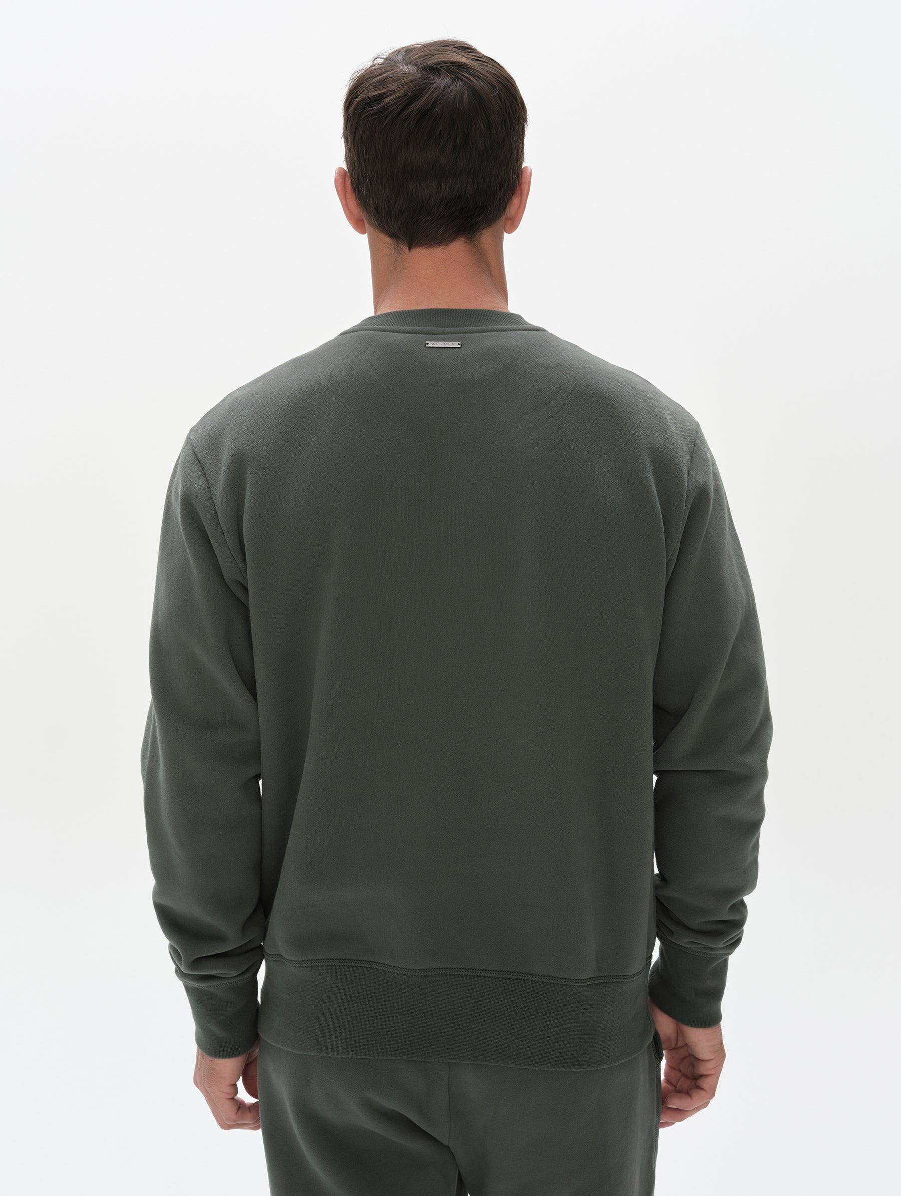 Rear, upper-body view of man wearing the Rylan Crewneck Sweatshirt in Saville Green from AETHER Apparel.