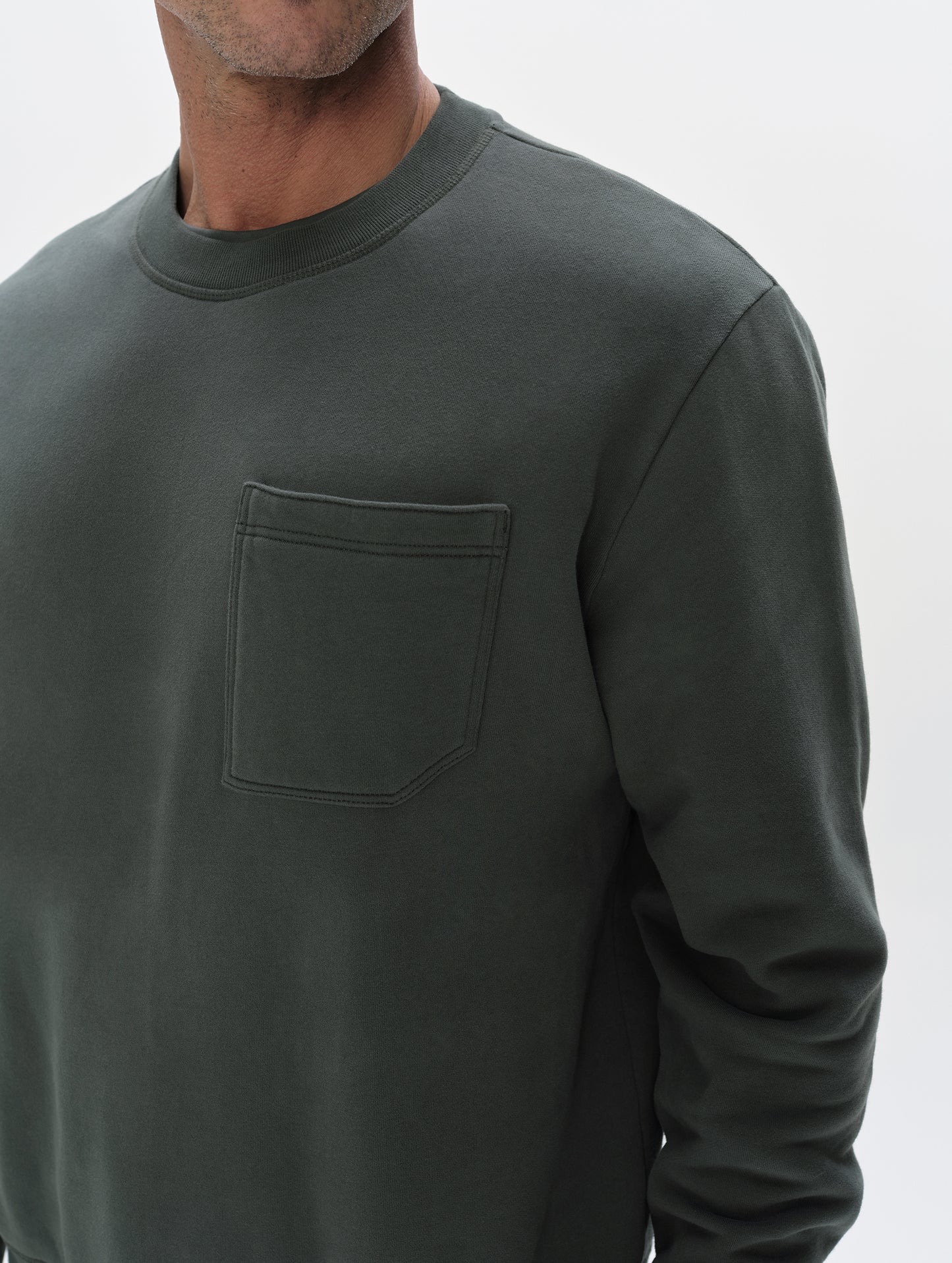 Closeup detailed view of the shoulder and chest pocket on the Rylan Crewneck Sweatshirt in Saville Green from AETHER Apparel.