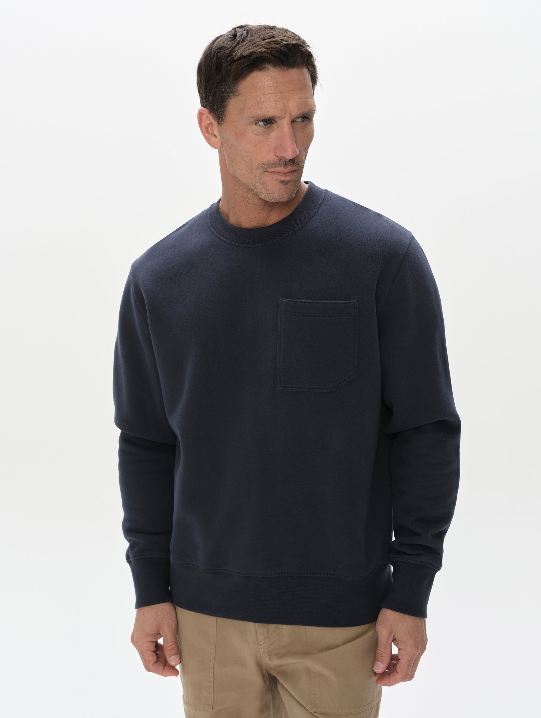 Front, upper-body view of man wearing the Rylan Crewneck Sweatshirt in Total Eclipse from AETHER Apparel.