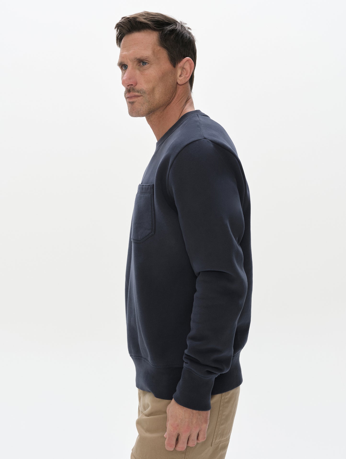 Side profile, upper-body view of man wearing the Rylan Crewneck Sweatshirt in Total Eclipse from AETHER Apparel.