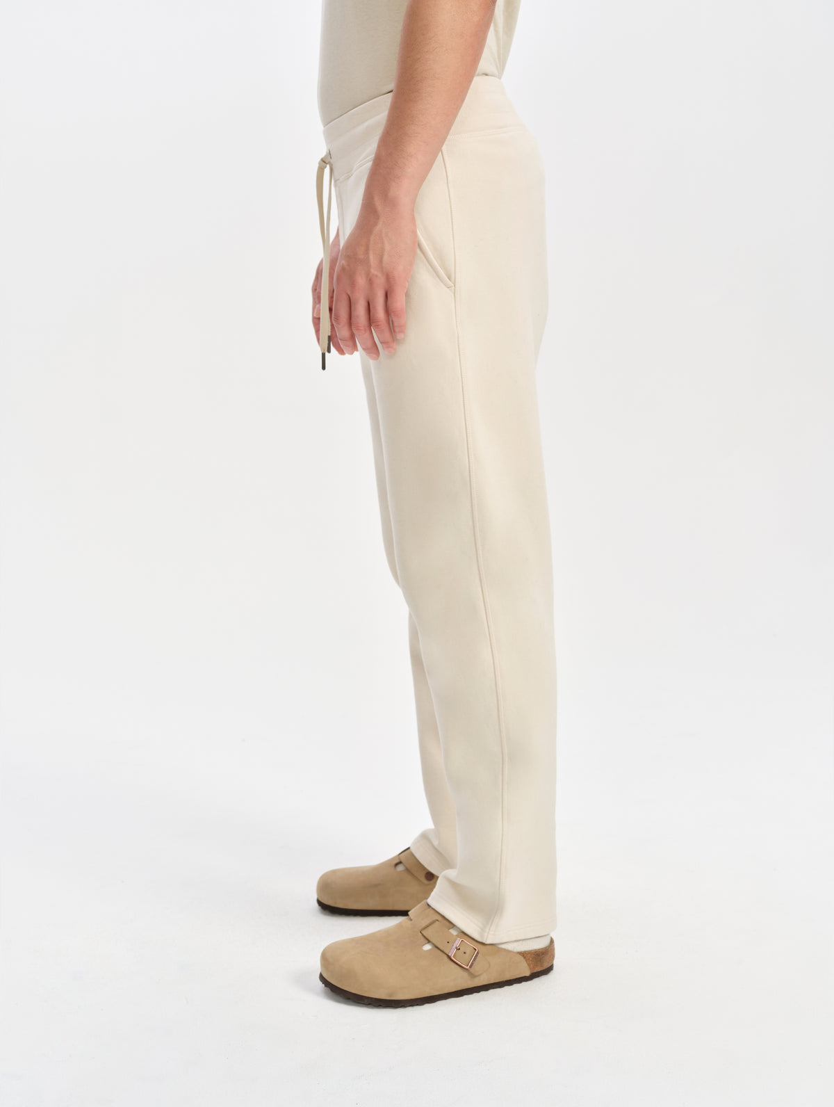 Side profile lower-body view of man wearing the Rylan Sweat Pant in Bone from AETHER Apparel. 