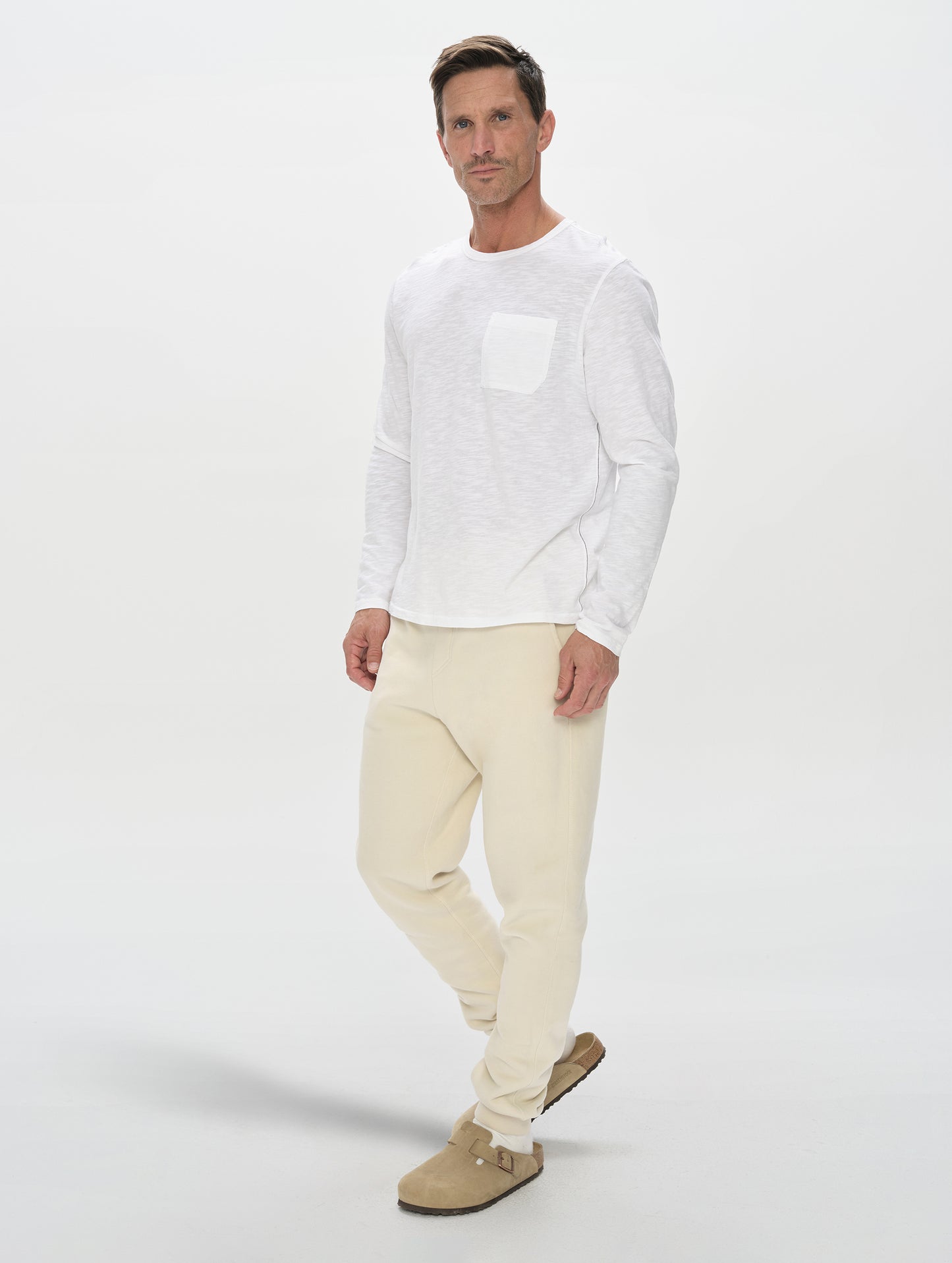 Front, full-body view of man wearing the Rylan Cuffed Sweatpant in Bone from AETHER Apparel.