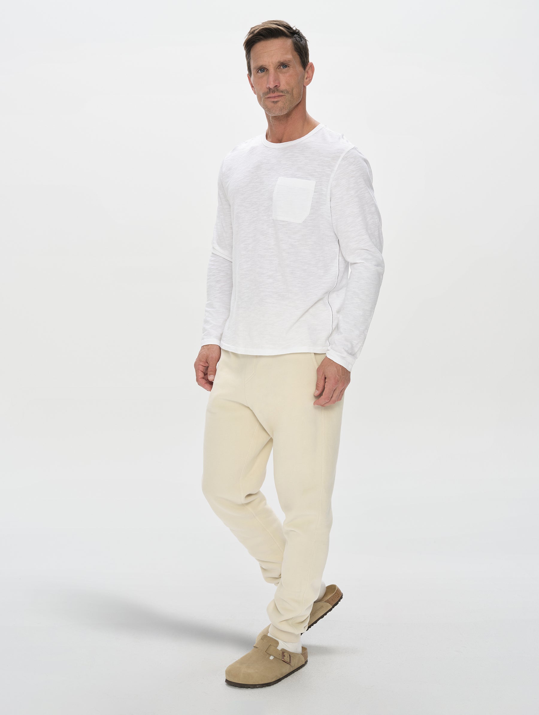 Front, full-body view of man wearing the Rylan Cuffed Sweatpant in Bone from AETHER Apparel.