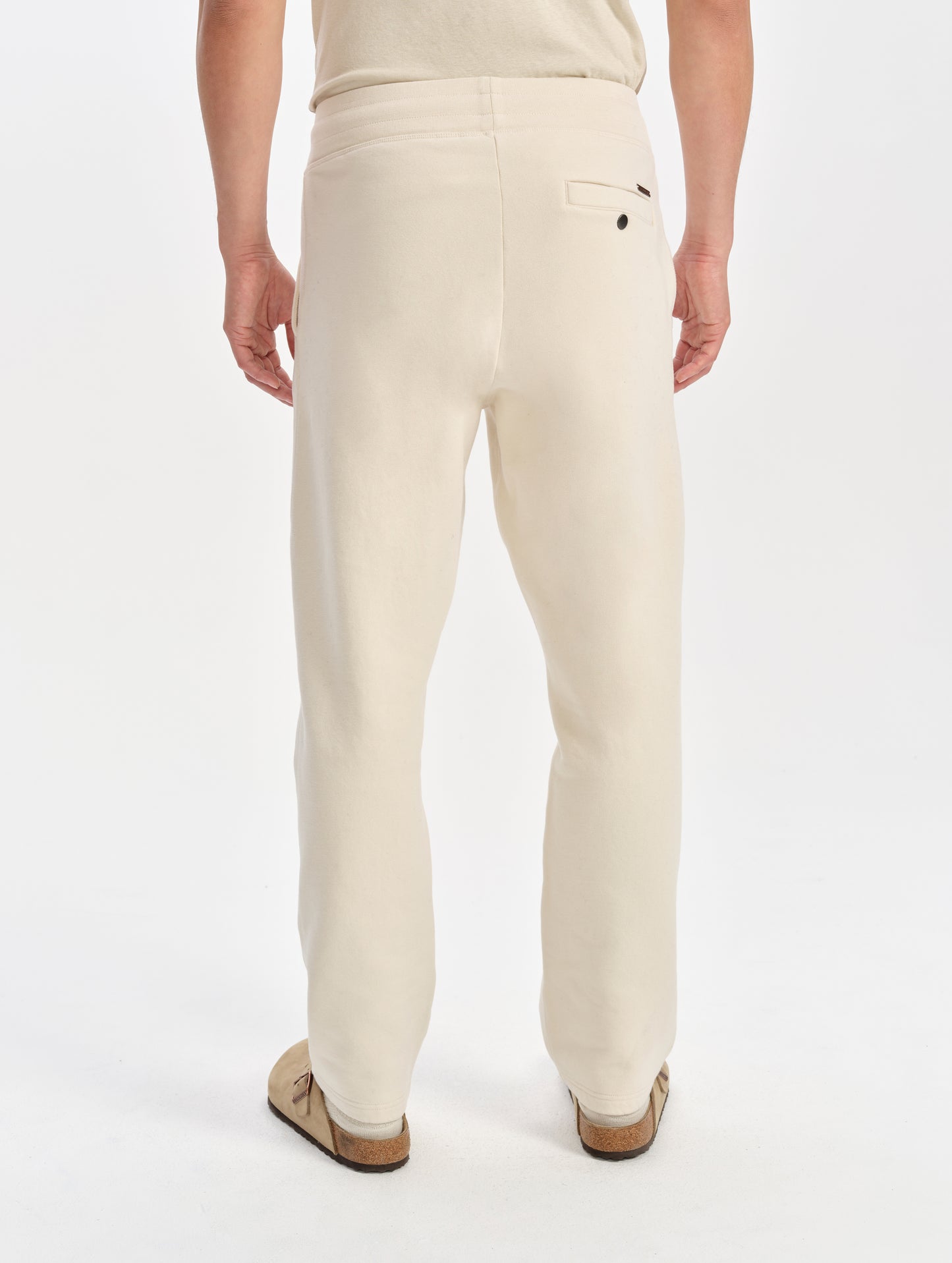 Rear lower-body view of man wearing the Rylan Sweat Pant in Bone from AETHER Apparel. 