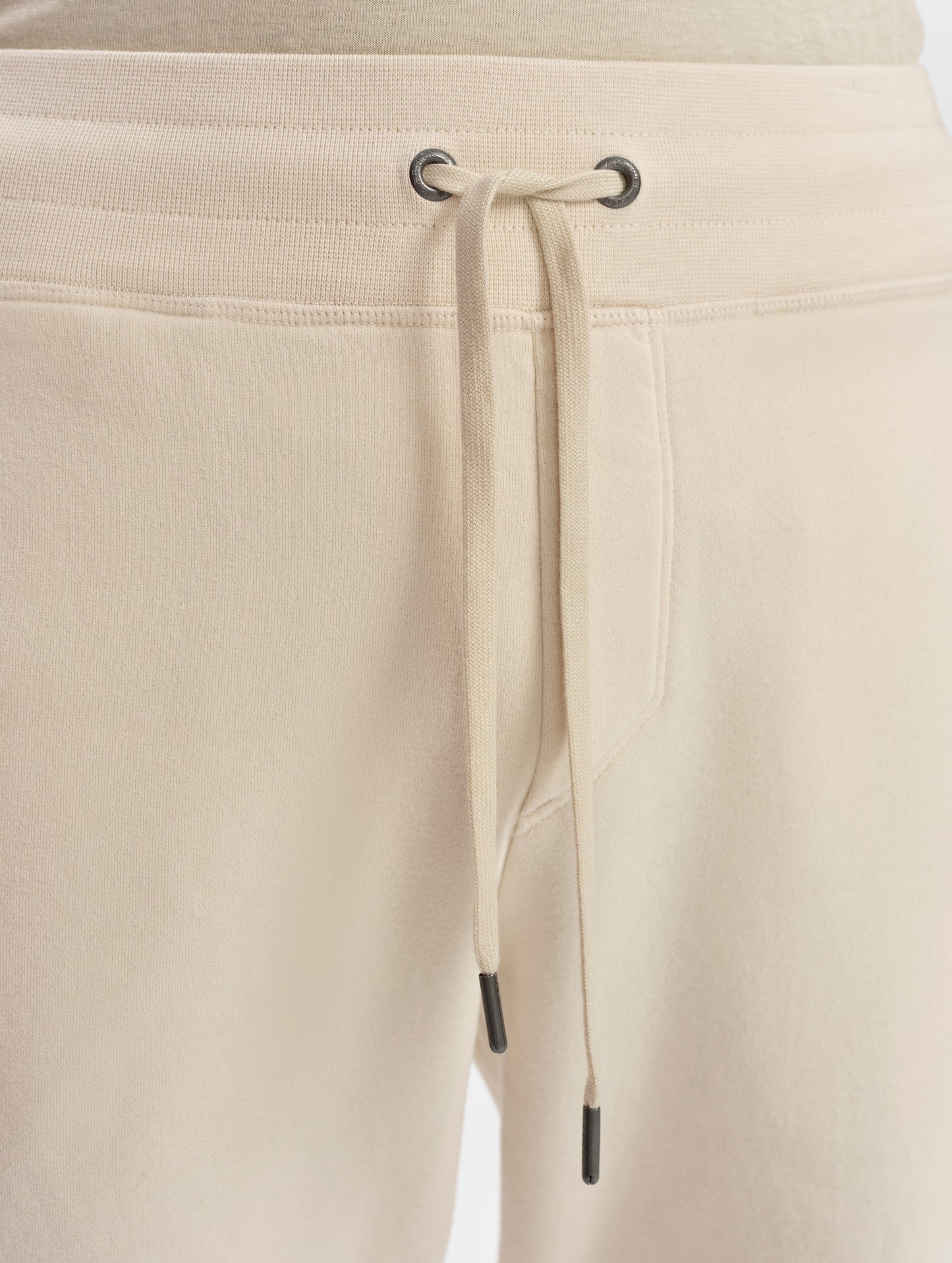 Closeup detailed view of the metal-tipped drawstring closure on the Rylan Sweat Pant in Bone from AETHER Apparel. 