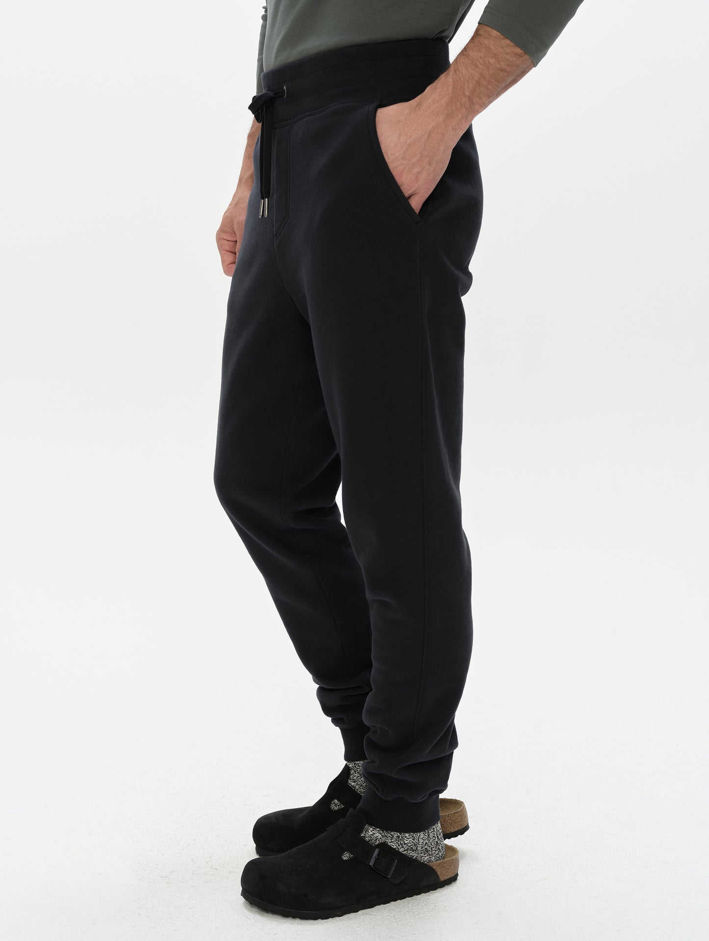 Side profile, lower-body view of man wearing the Rylan Cuffed Sweatpant in Onyx Black from AETHER Apparel.