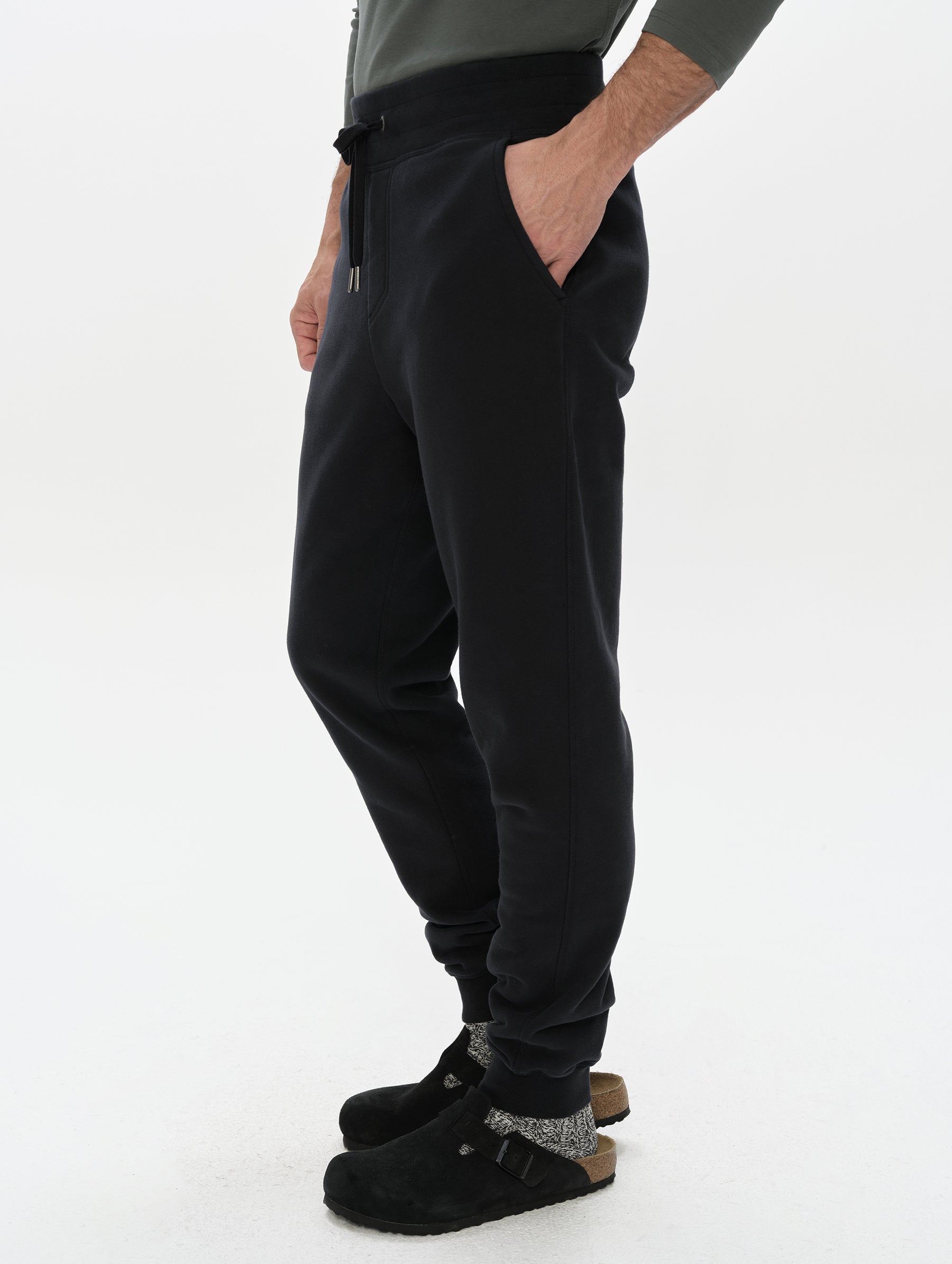 Side profile, lower-body view of man wearing the Rylan Cuffed Sweatpant in Onyx Black from AETHER Apparel.