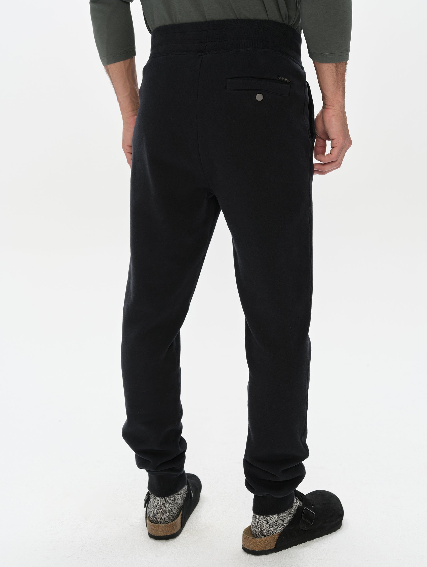 Rear, lower-body view of man wearing the Rylan Cuffed Sweatpant in Onyx Black from AETHER Apparel.